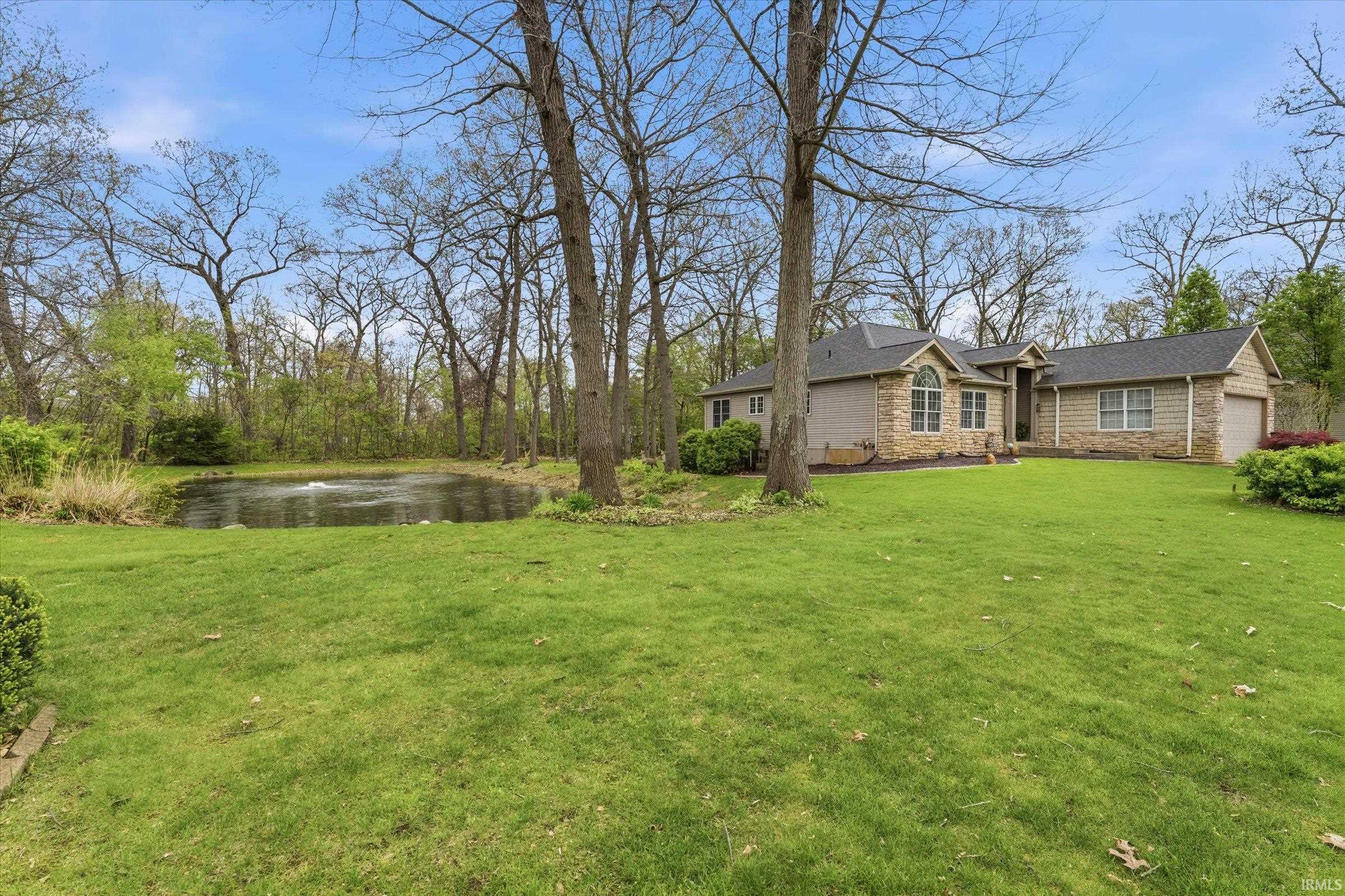 Expansive lawn area featuring a private pond with a fountain