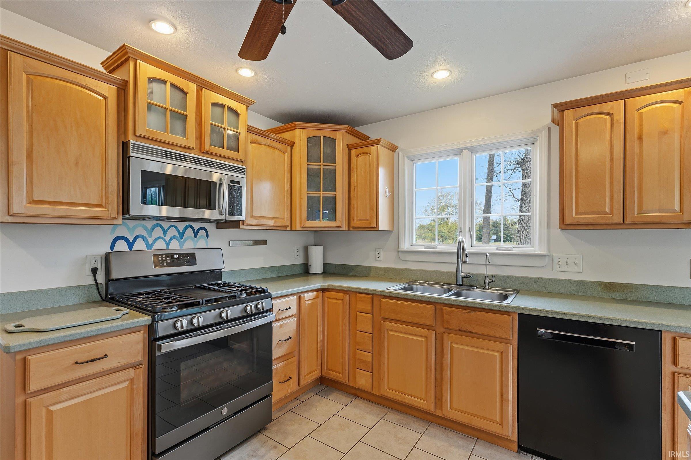 Kitchen featuring light wood cabinetry, light green countertops, and tile flooring