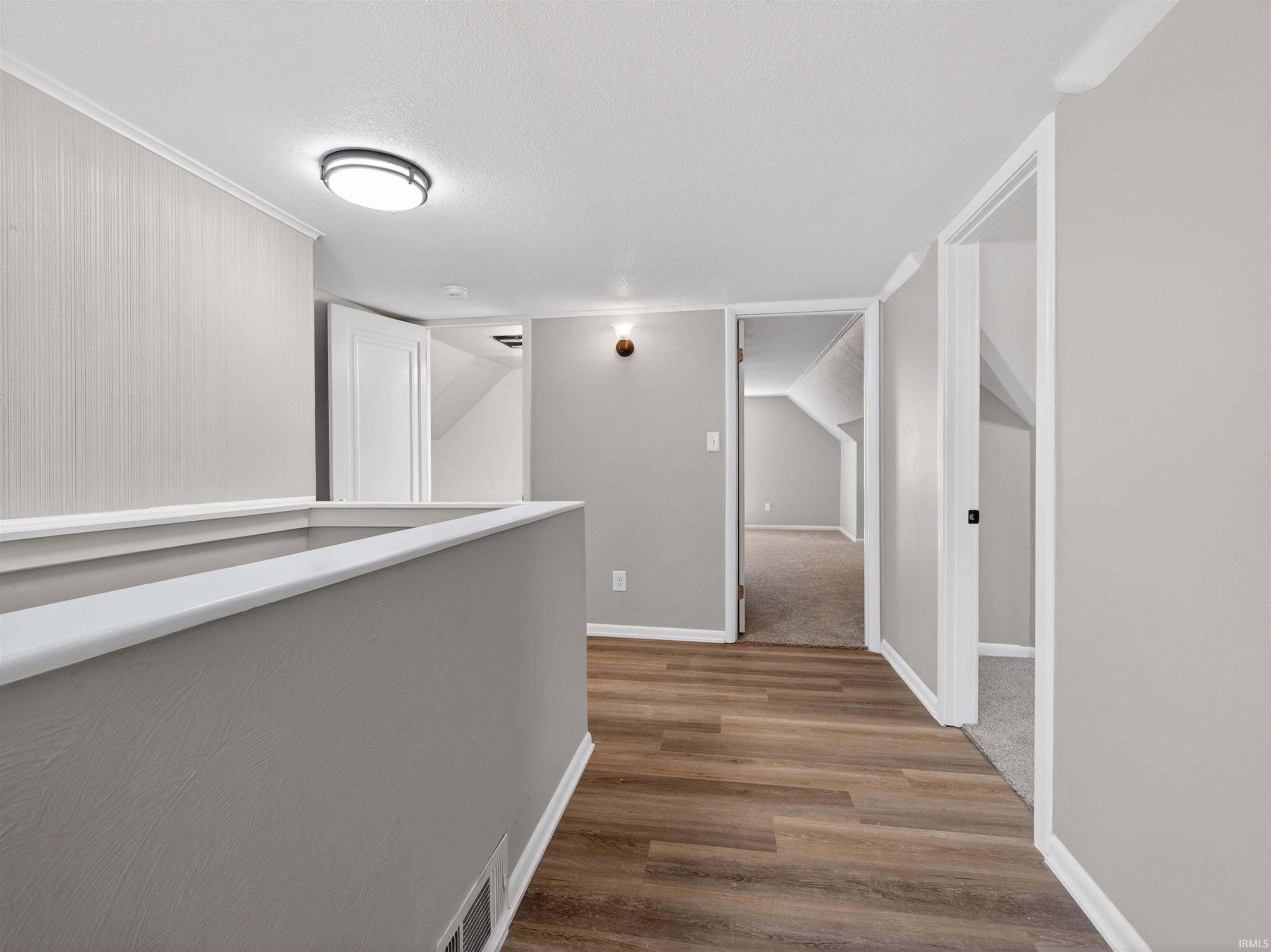 Upper-level landing featuring wood-finish flooring