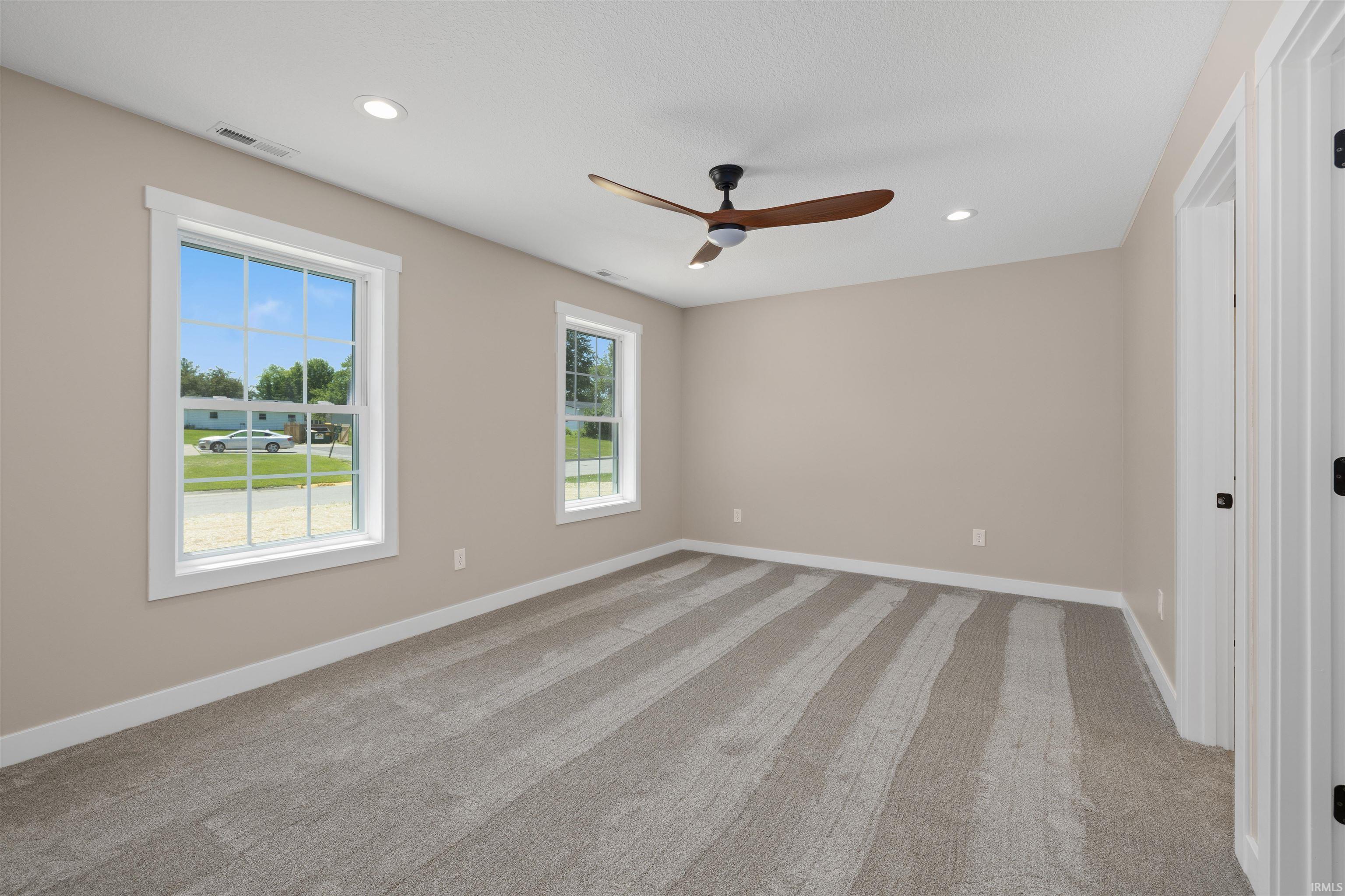 Spacious room featuring neutral paint, grey carpet, and white trim