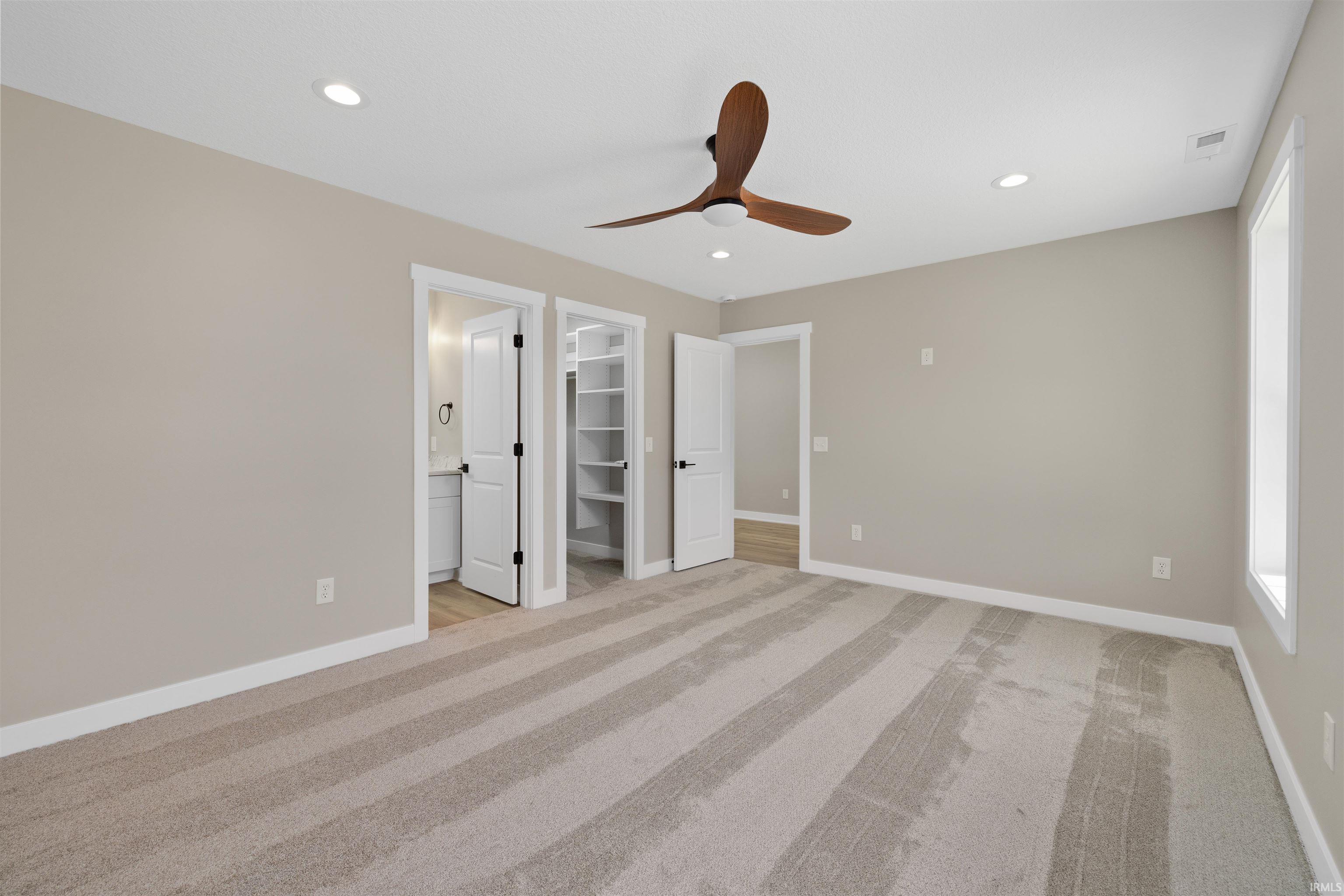 Spacious room featuring neutral carpeting and light neutral wall tones