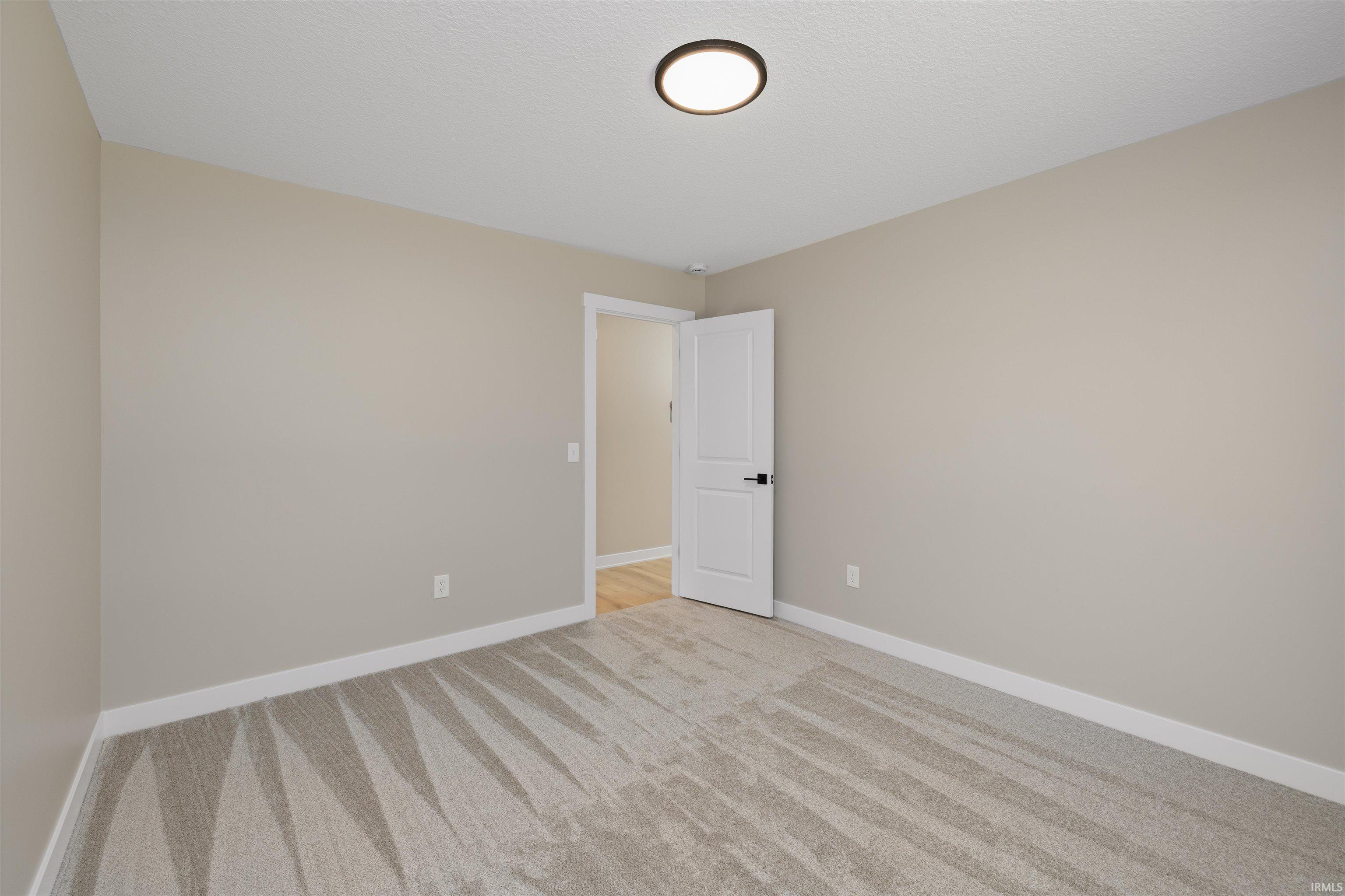 Neutral-toned room with light gray walls, white trim, and patterned gray carpeting