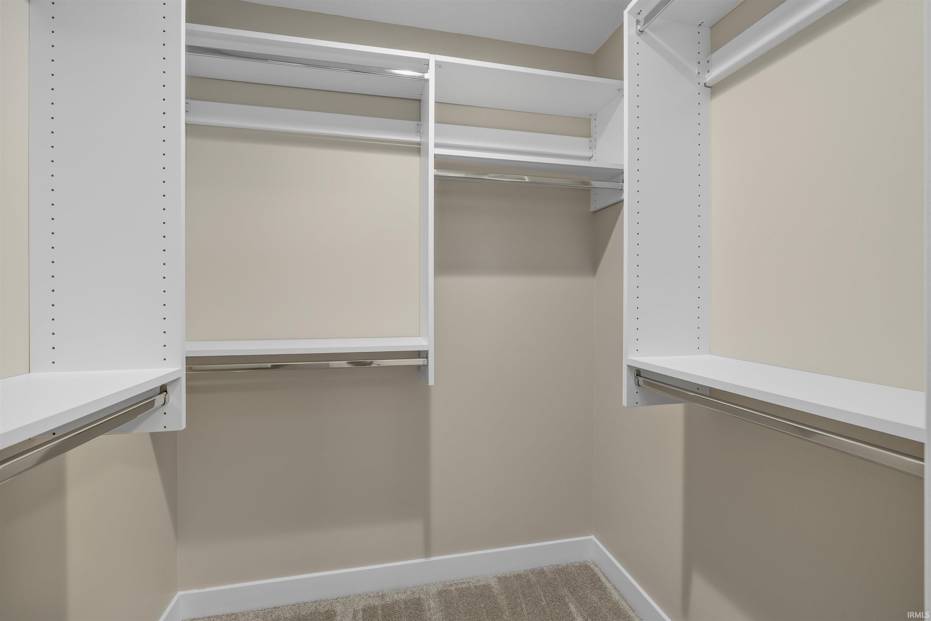 Custom closet system featuring white shelving and hanging rods