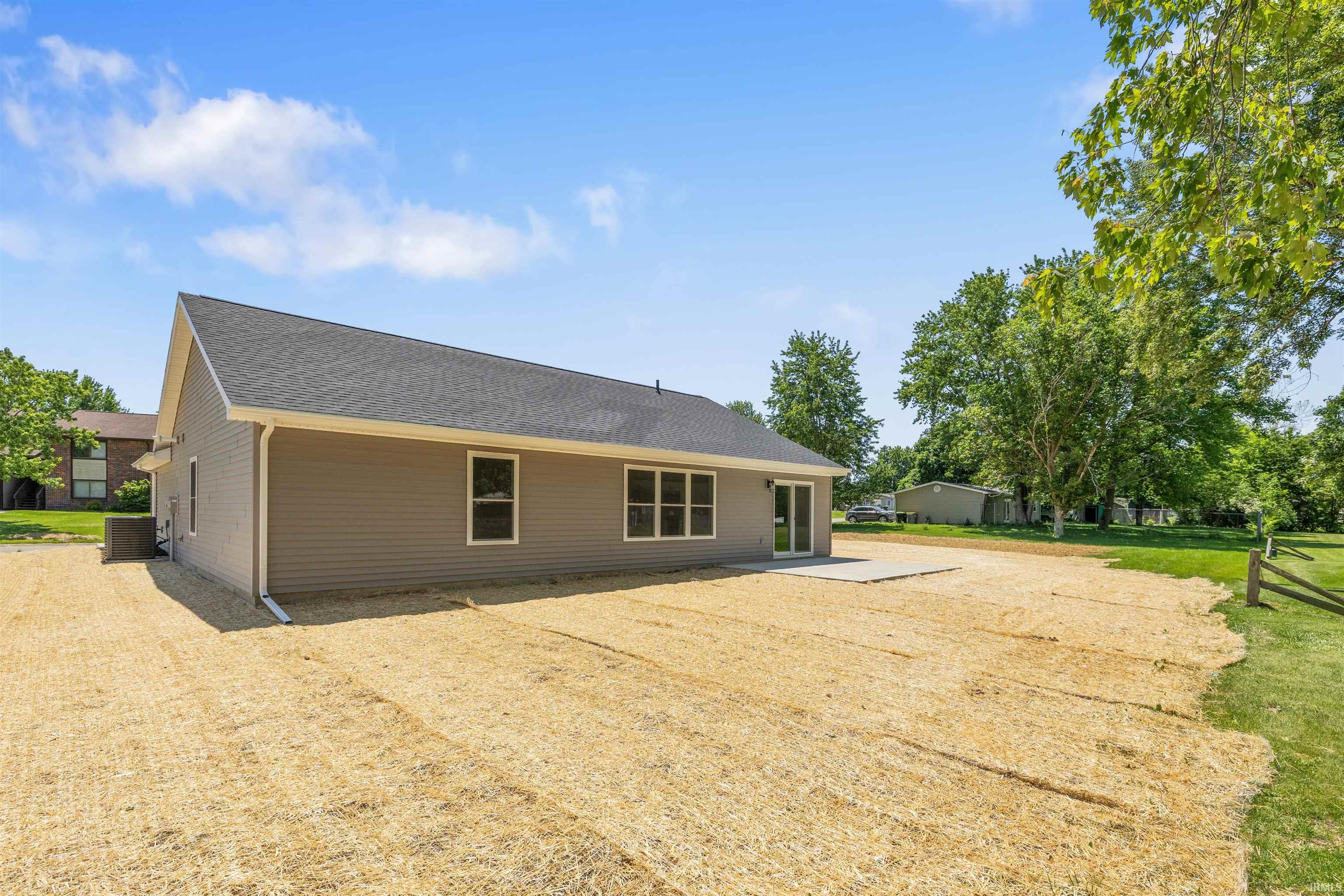 Rear exterior featuring light grey horizontal siding and white trim