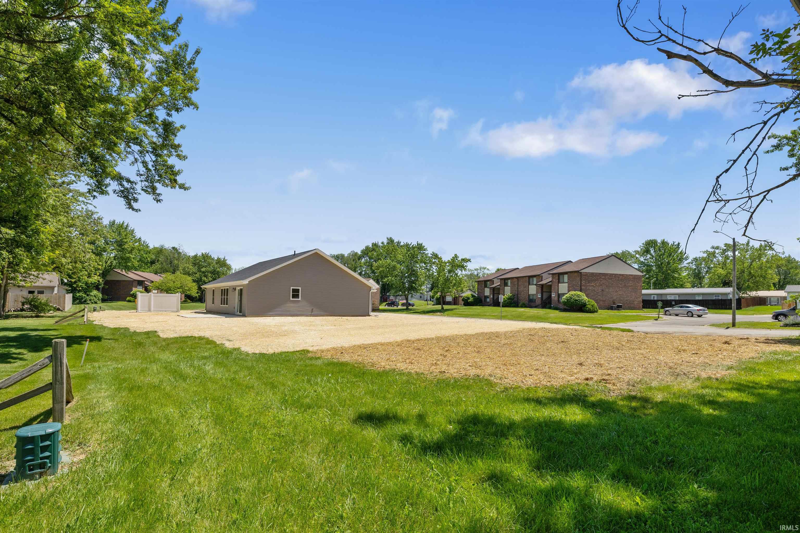 Spacious rear exterior featuring a neutral tone stucco finish and a dark shingle roof