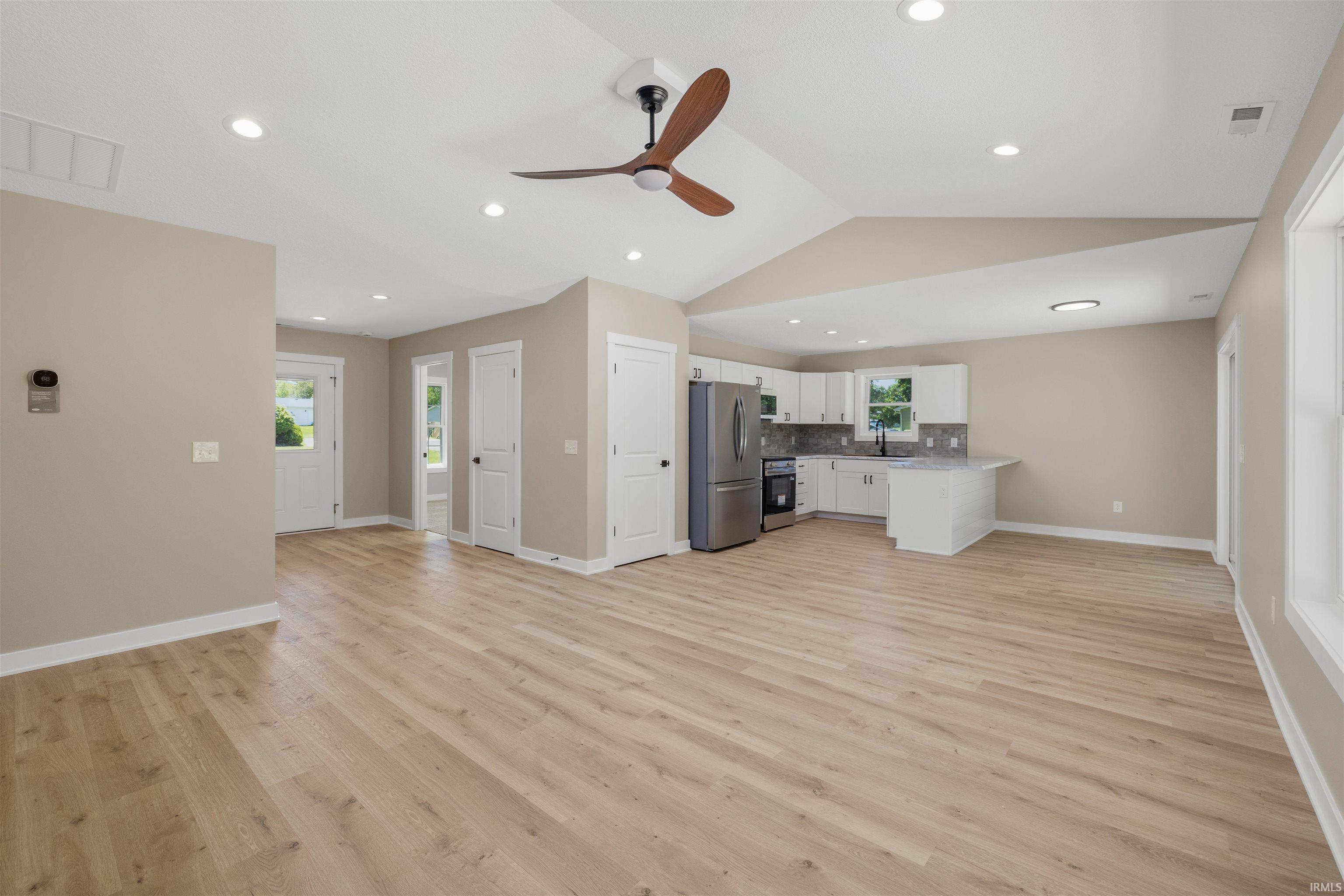 Open-concept living space featuring wood-finish flooring and recessed lighting