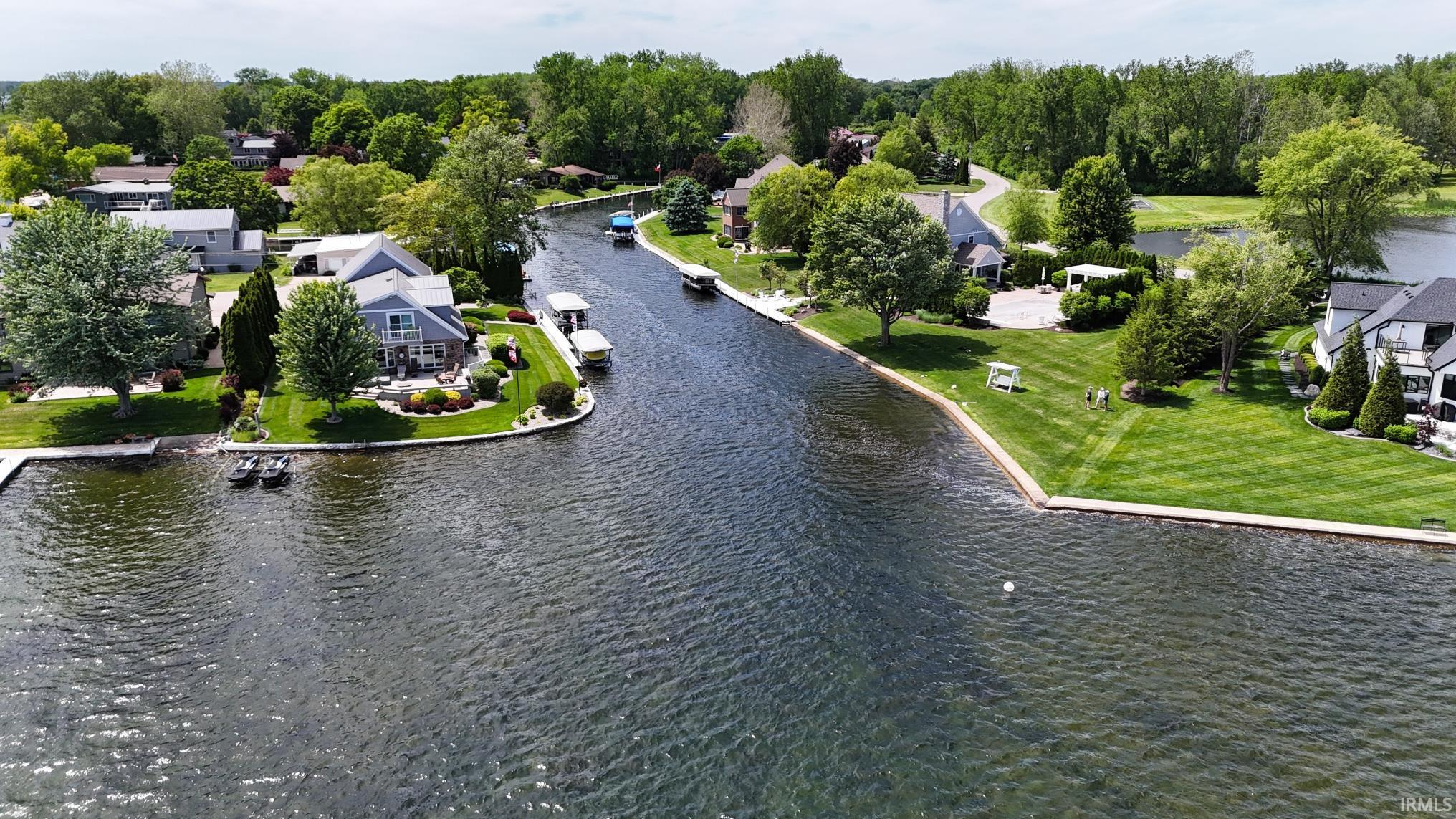 Waterfront property featuring extensive shoreline, mature trees, and manicured lawns