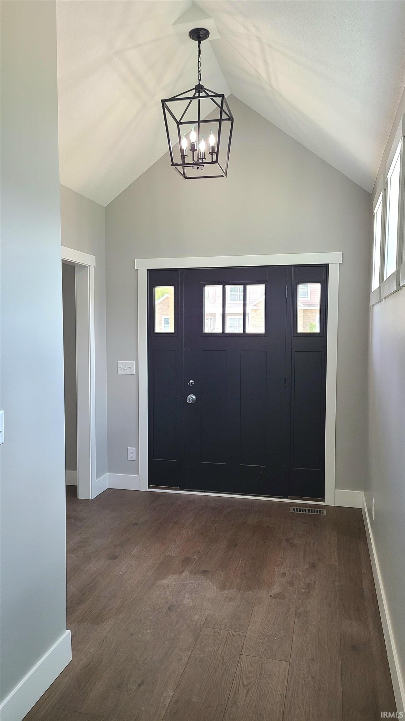 Vaulted ceiling entryway featuring a black geometric chandelier