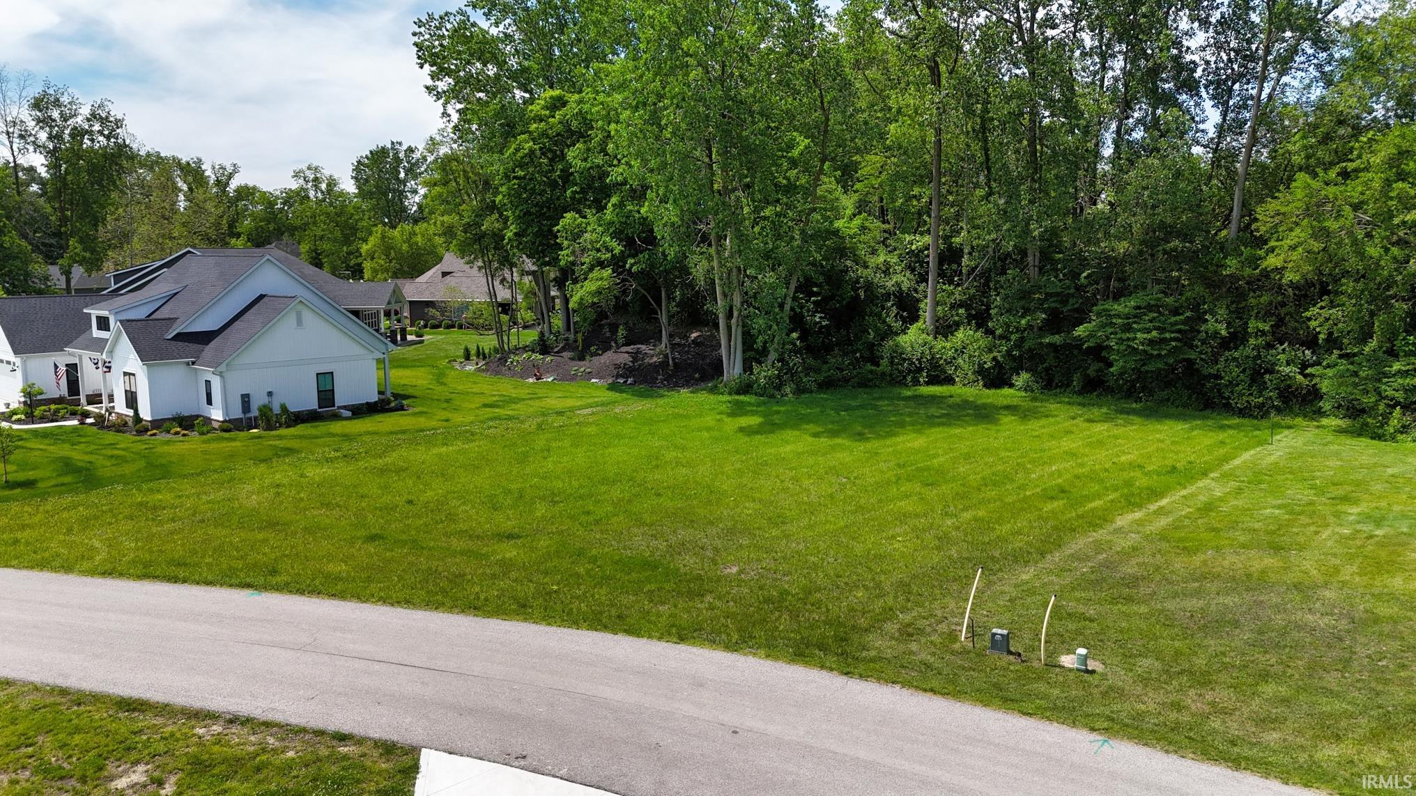 Expansive residential lot featuring a manicured lawn and mature tree line