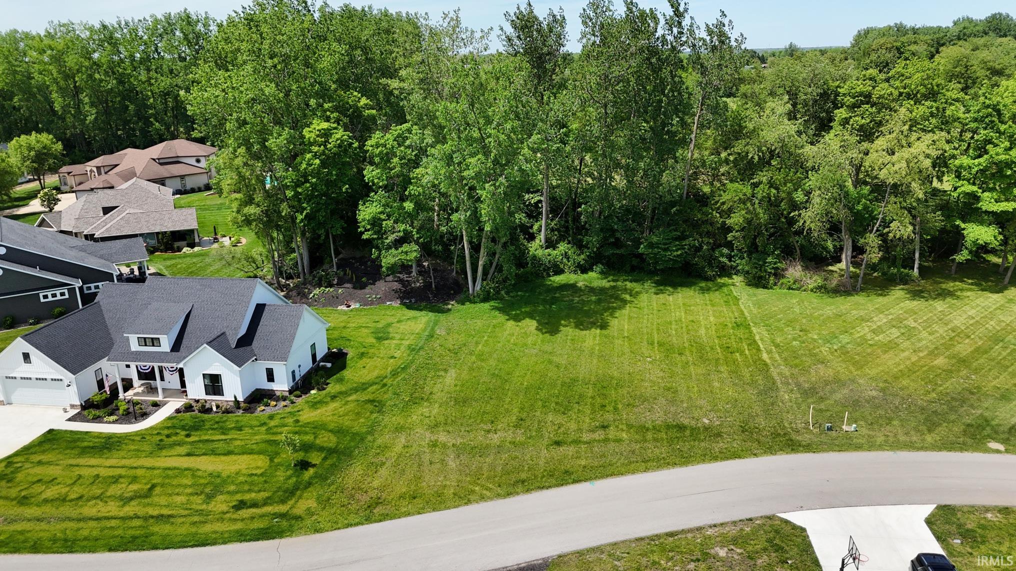 Expansive green lawn bordering a wooded area