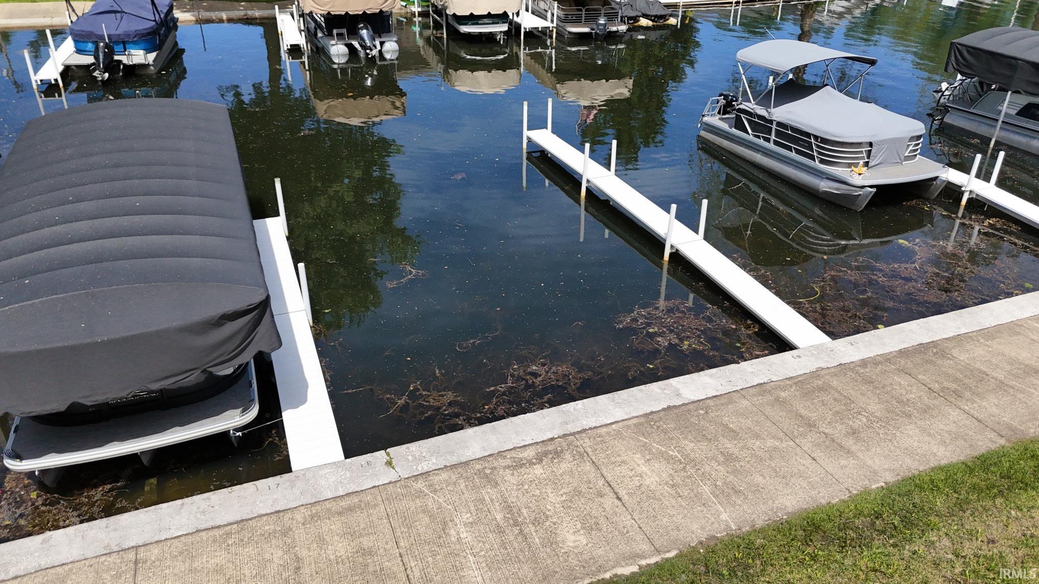 Waterfront access featuring concrete dock infrastructure and two boat slips