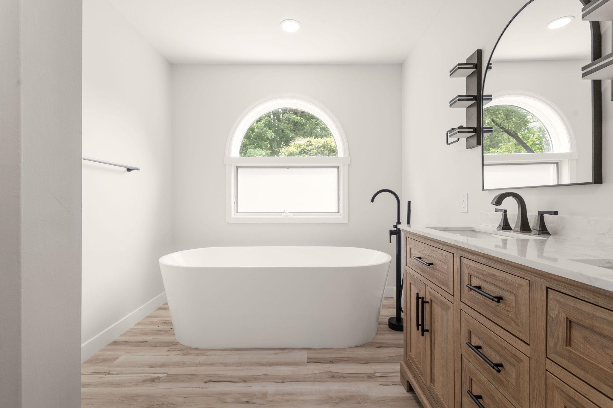 Freestanding soaking tub with arched window above