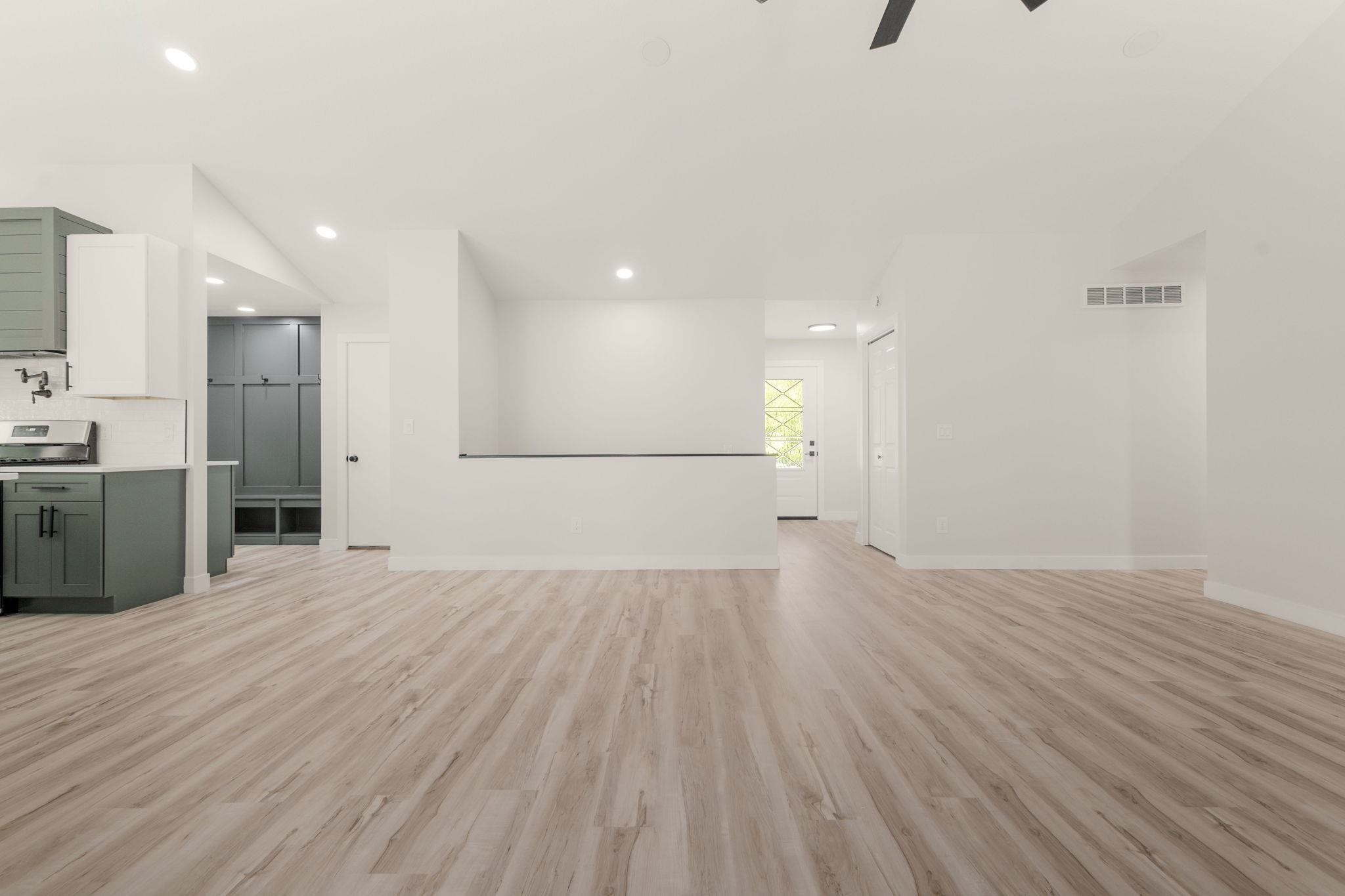 Expansive room featuring wood-finish flooring, white walls, and recessed lighting
