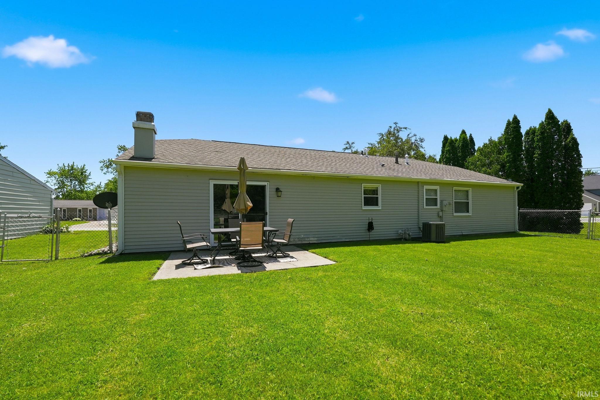 Expansive green lawn with a concrete patio