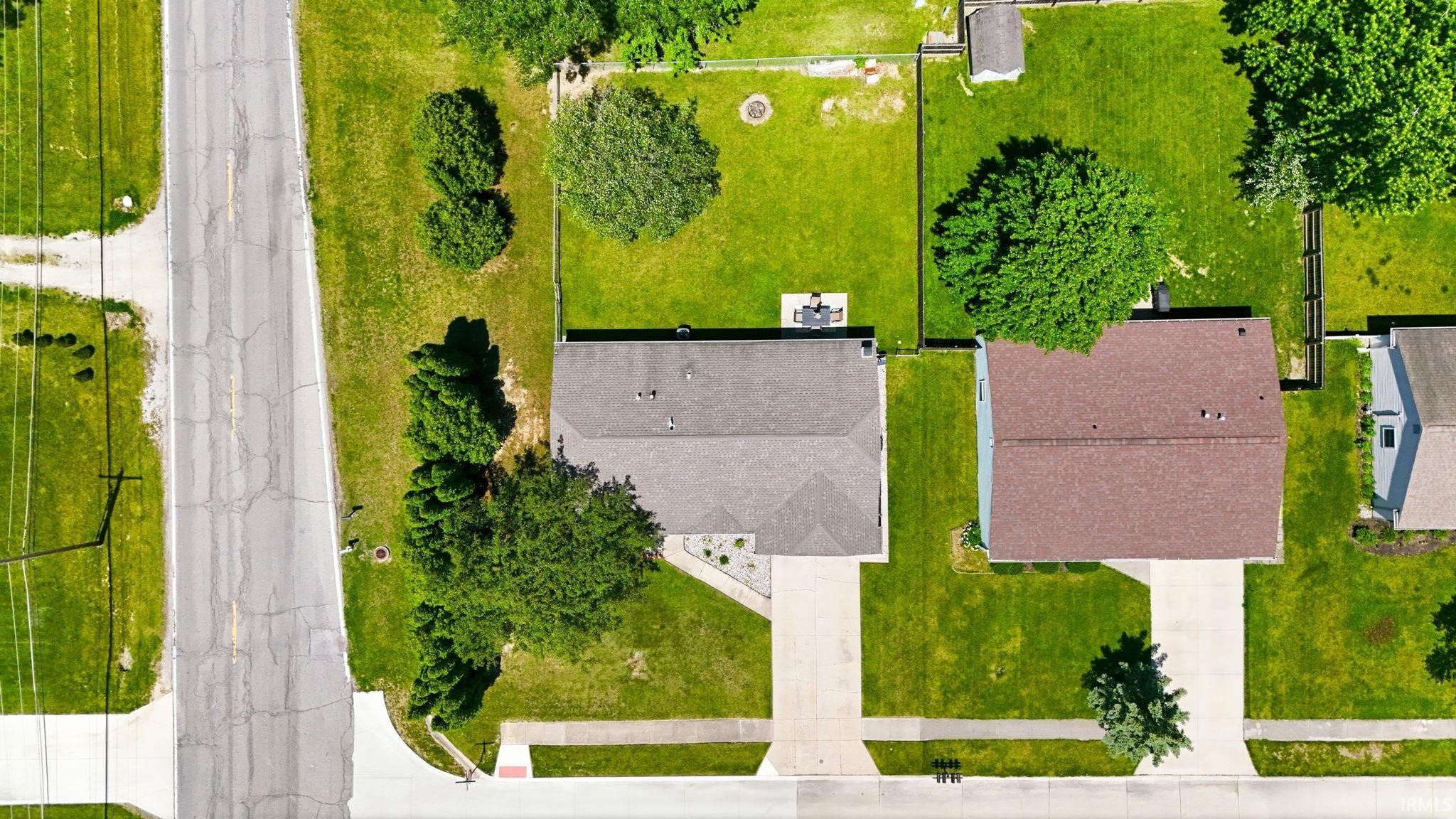 Aerial view showcasing a residential property with a brown shingled roof