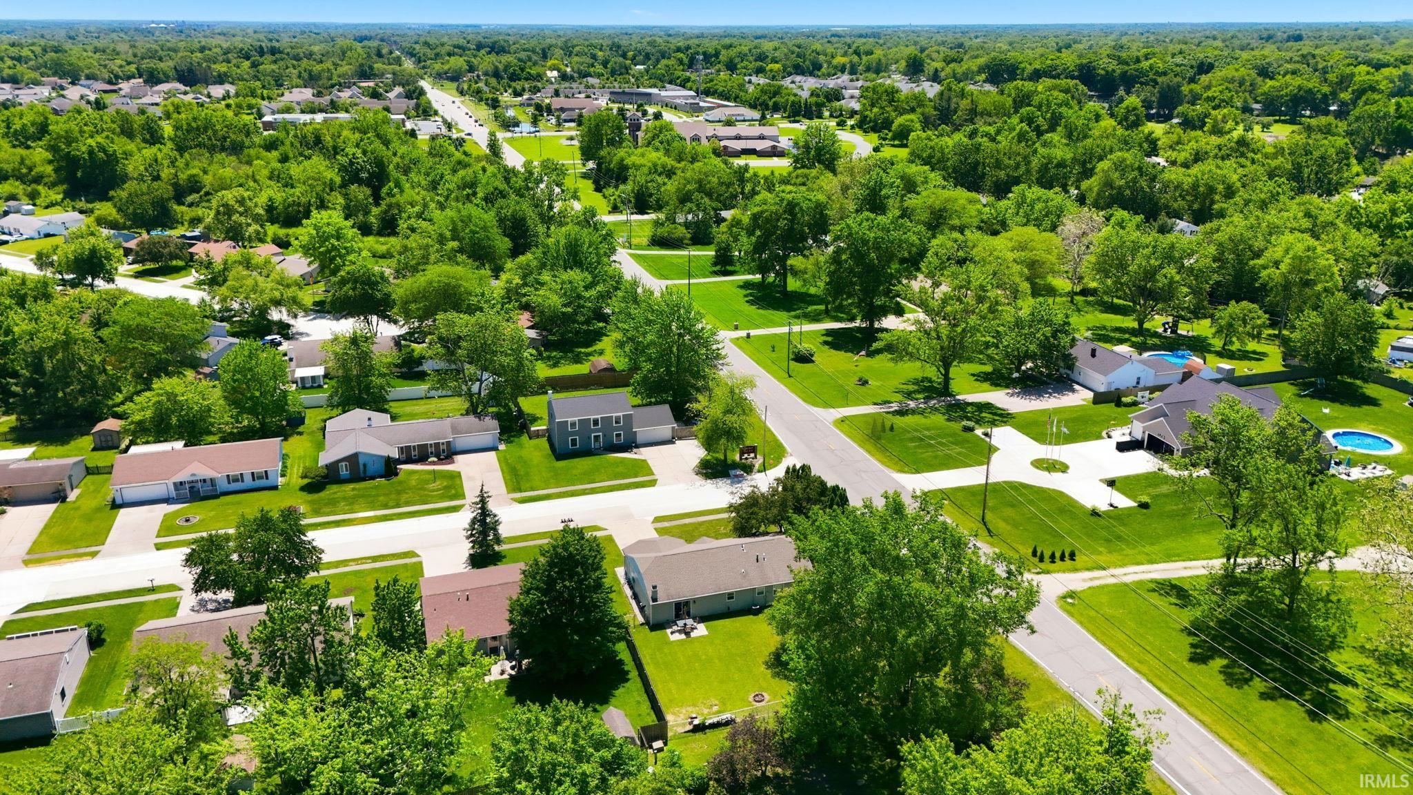 Established residential neighborhood featuring mature trees, manicured lawns, and asphalt roadways