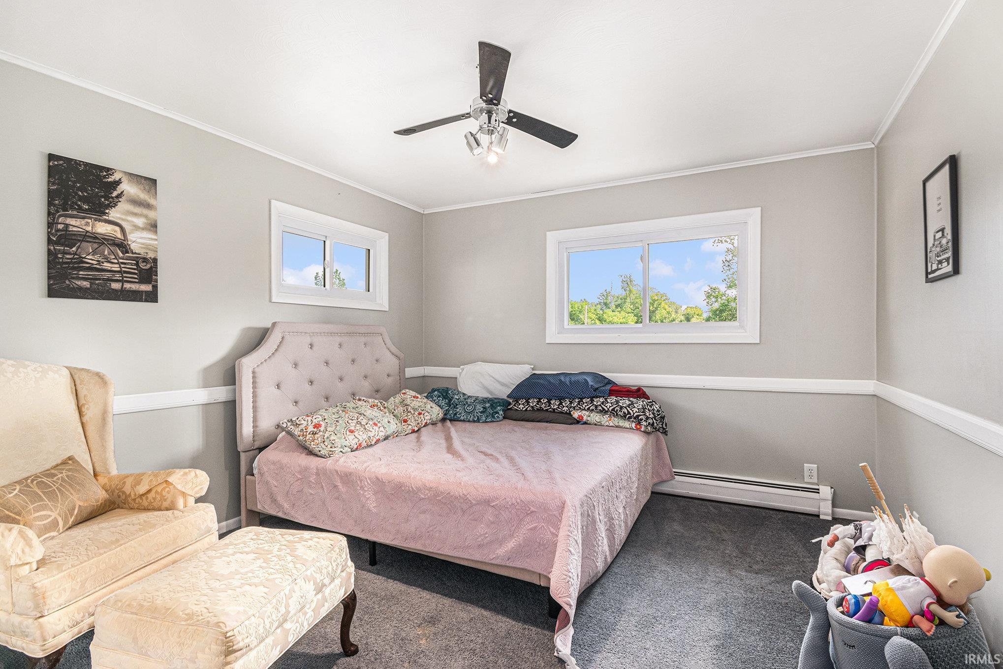 Carpeted room with light gray walls, white crown molding, and chair rail detailing