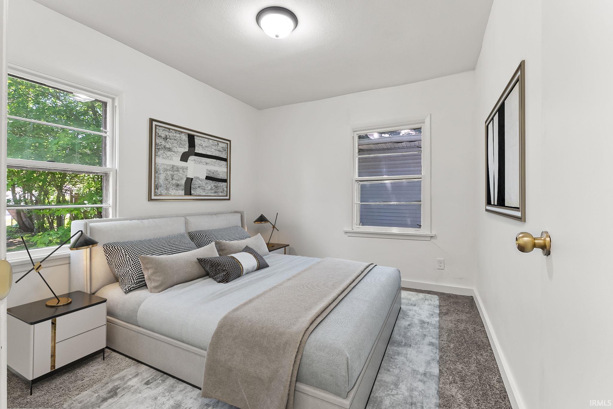 Neutral tone bedroom featuring white walls and a light-colored carpet