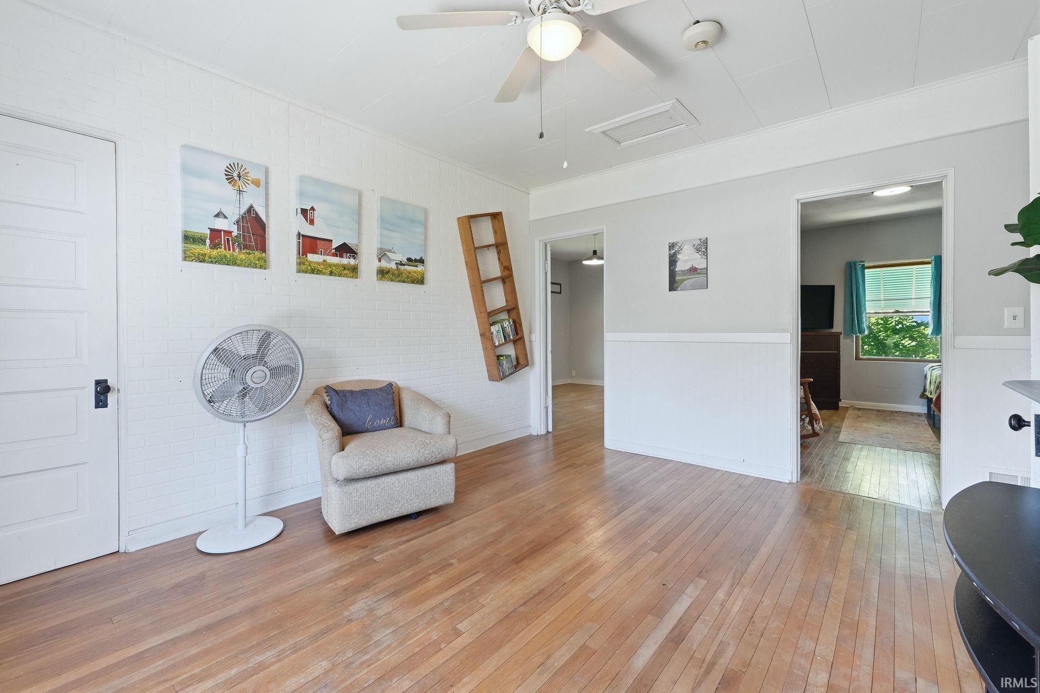 Hardwood flooring extends throughout this interior, complemented by a white ceiling with a ceiling fan light fixture