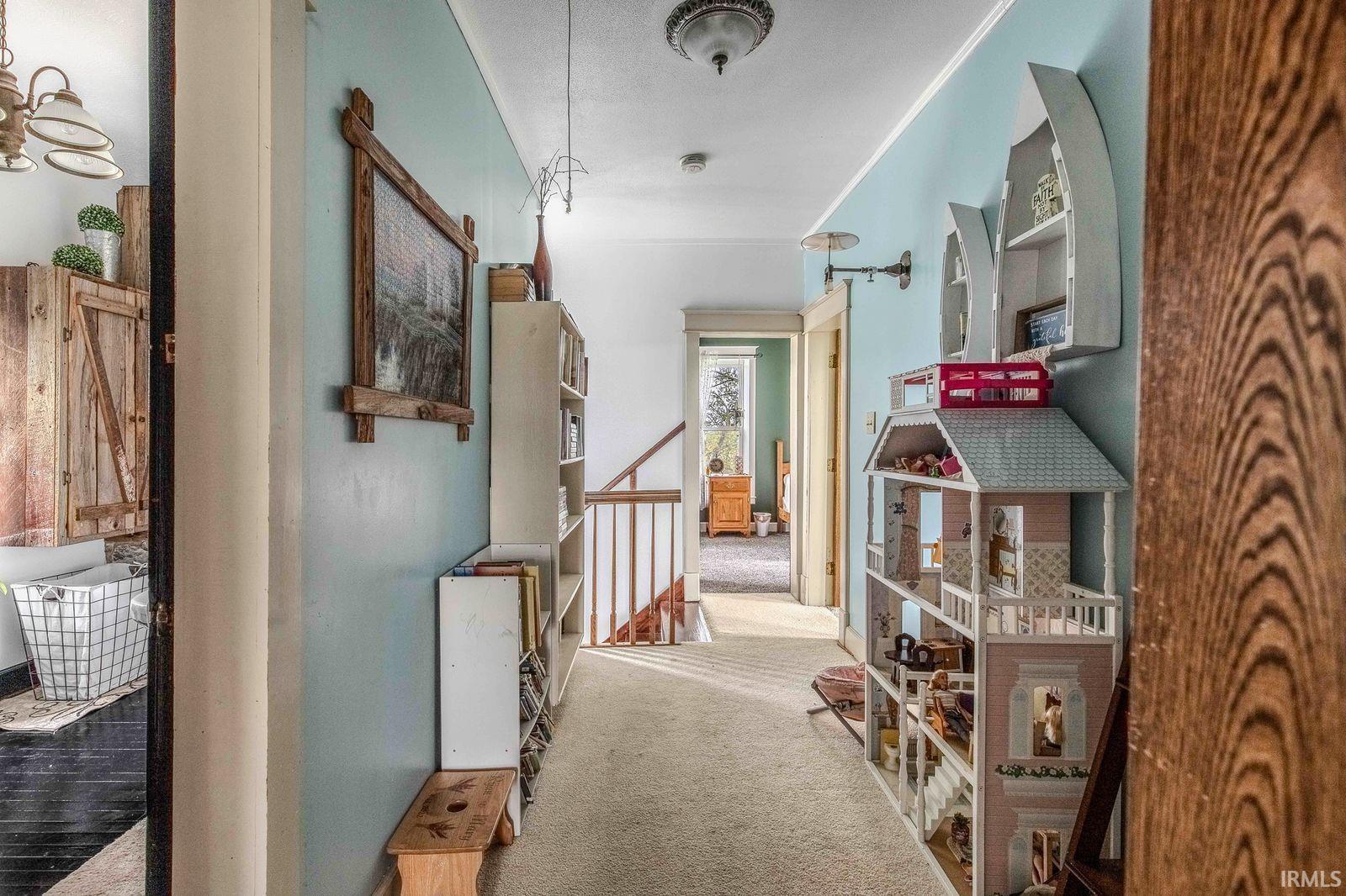 Carpeted hallway featuring light blue walls, a white ceiling, and a flush mount ceiling light fixture