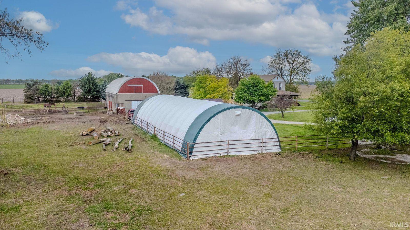Large arched tension fabric structure featuring a white cover and green trim