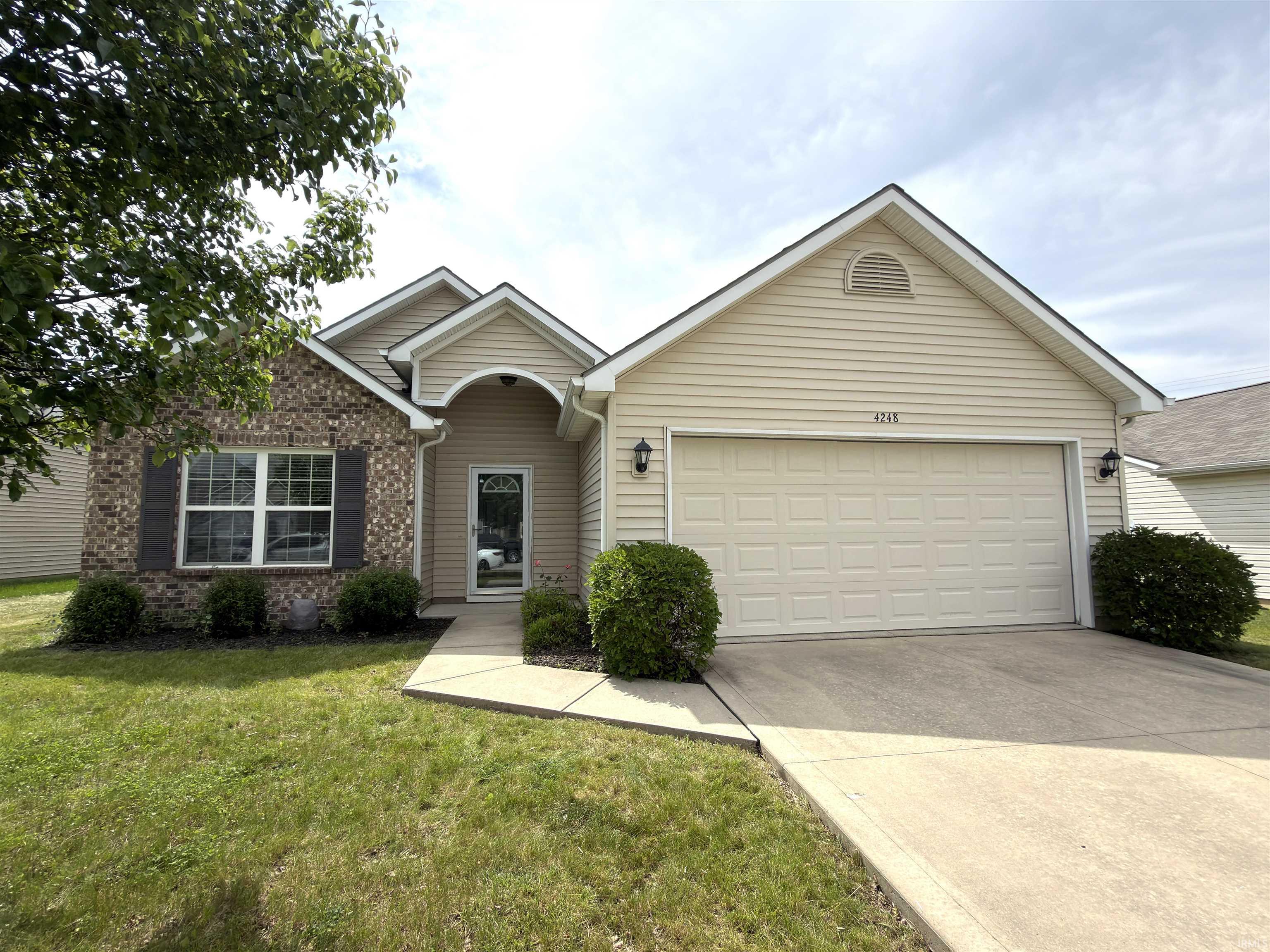 Single-story residence featuring a brick and siding exterior, an attached two-car garage, and a concrete driveway