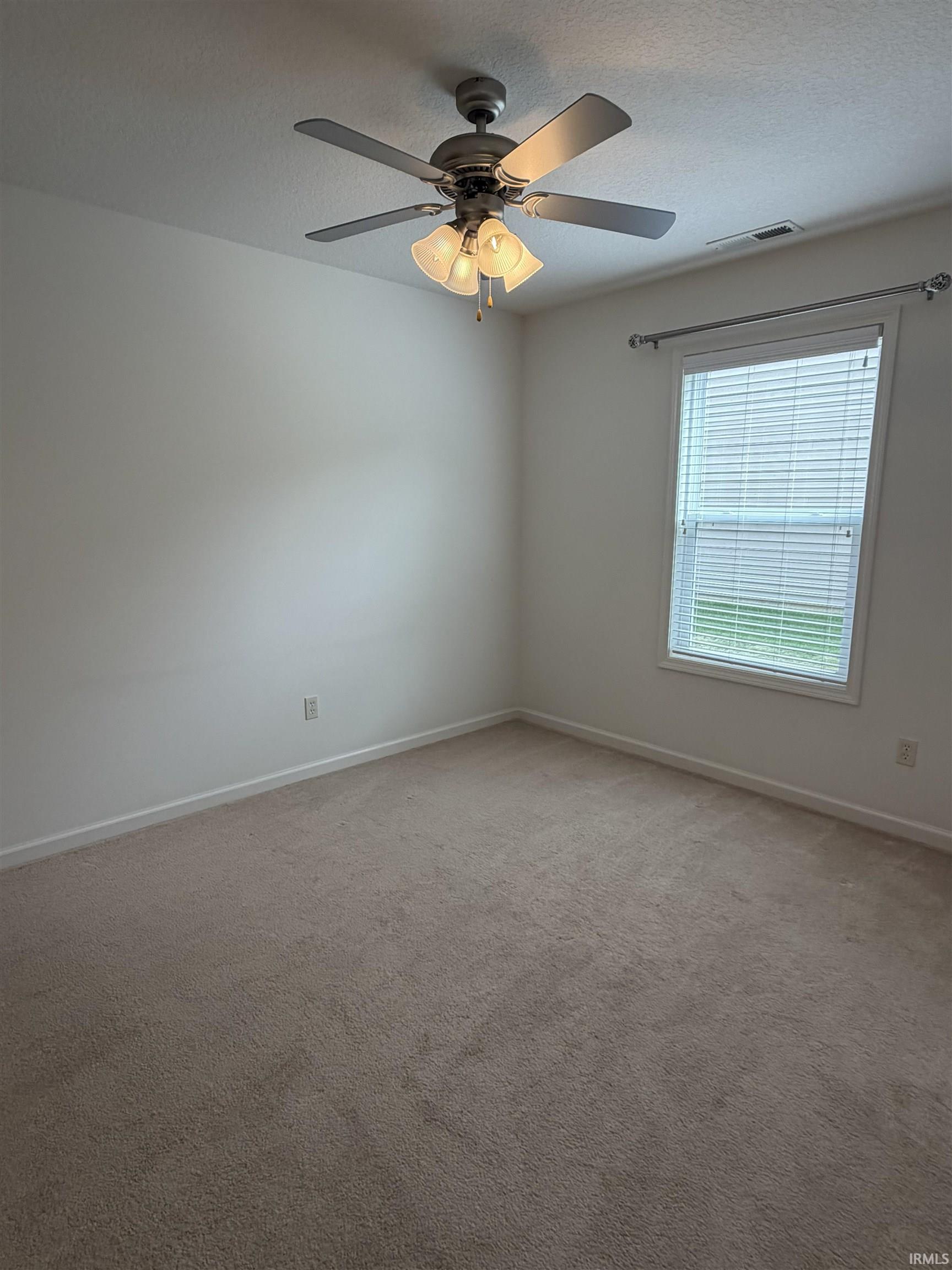 Neutral-toned carpeting extends throughout this room, complemented by white walls and trim