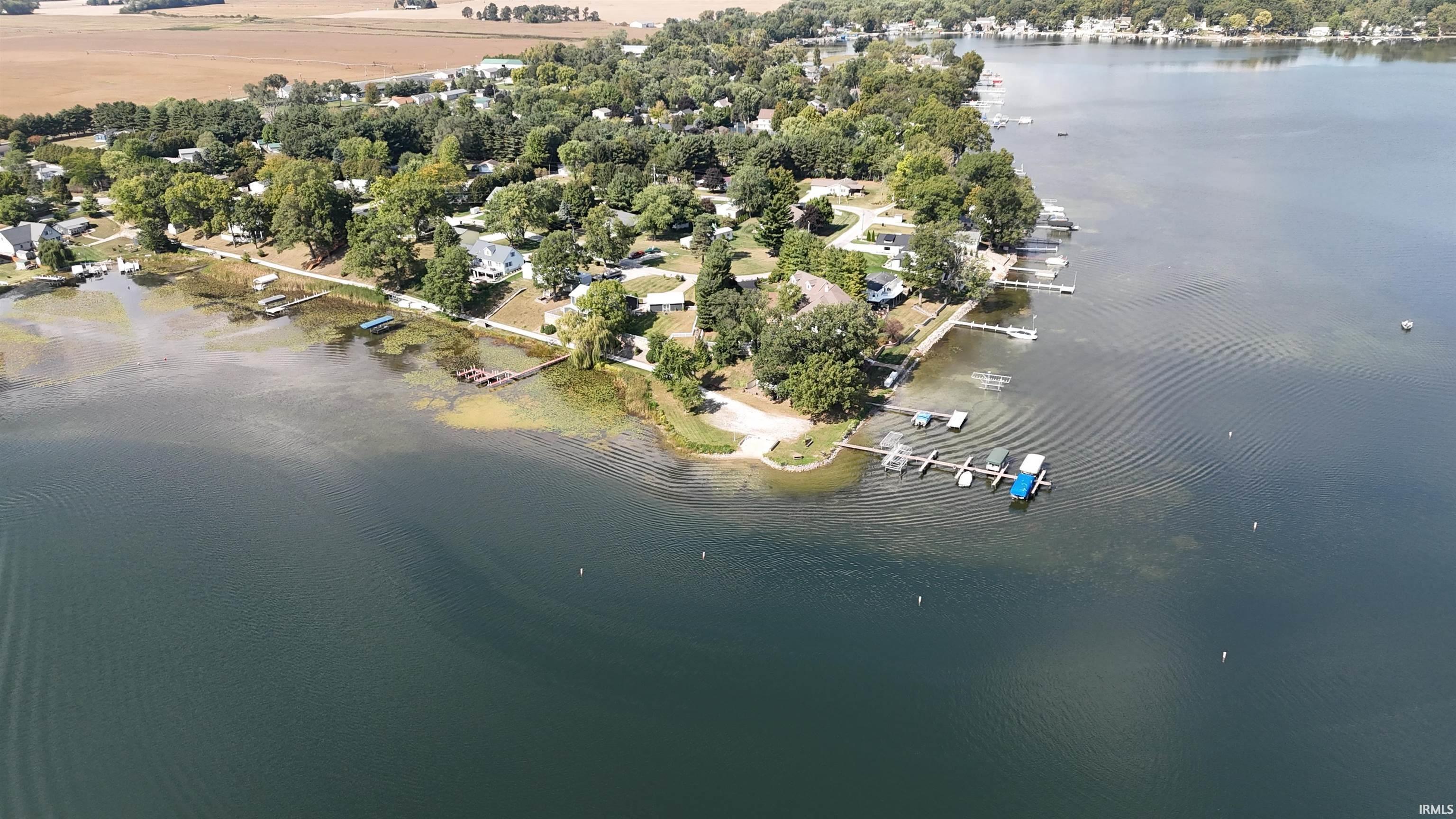 Expansive lakefront property featuring multiple boat docks, direct water access, and mature trees