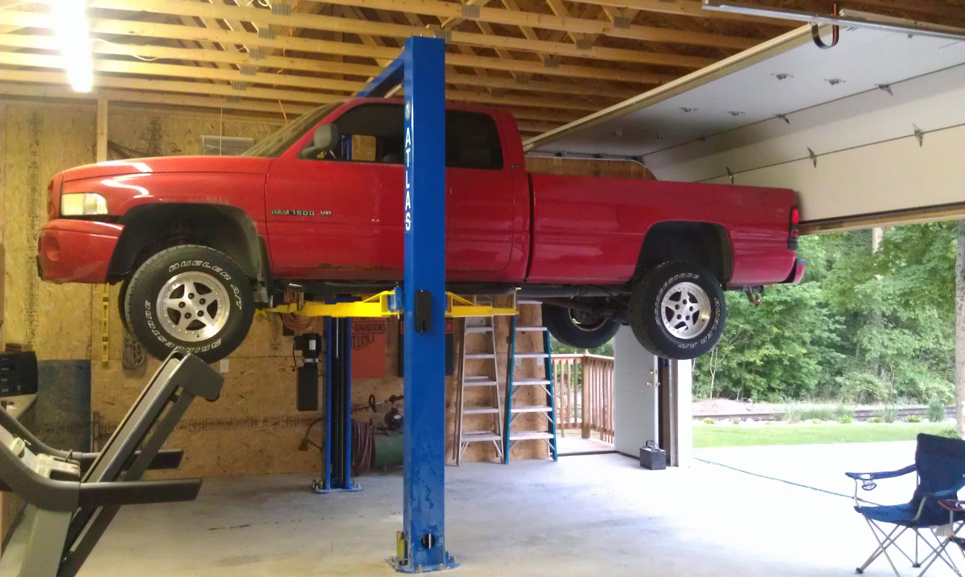 Garage space featuring exposed beam ceiling, concrete flooring, and a large overhead door