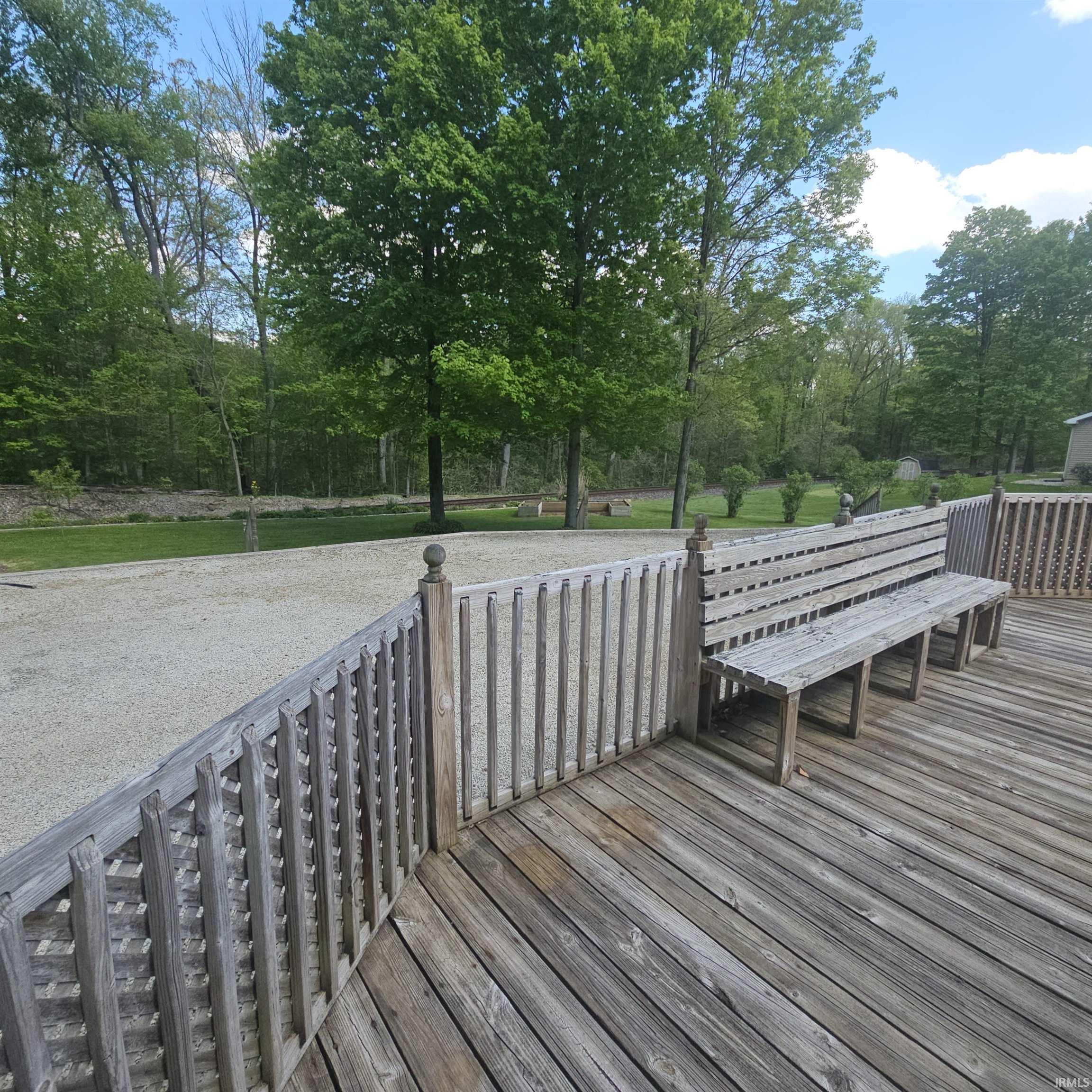 Expansive wood deck with built-in bench seating and baluster railing