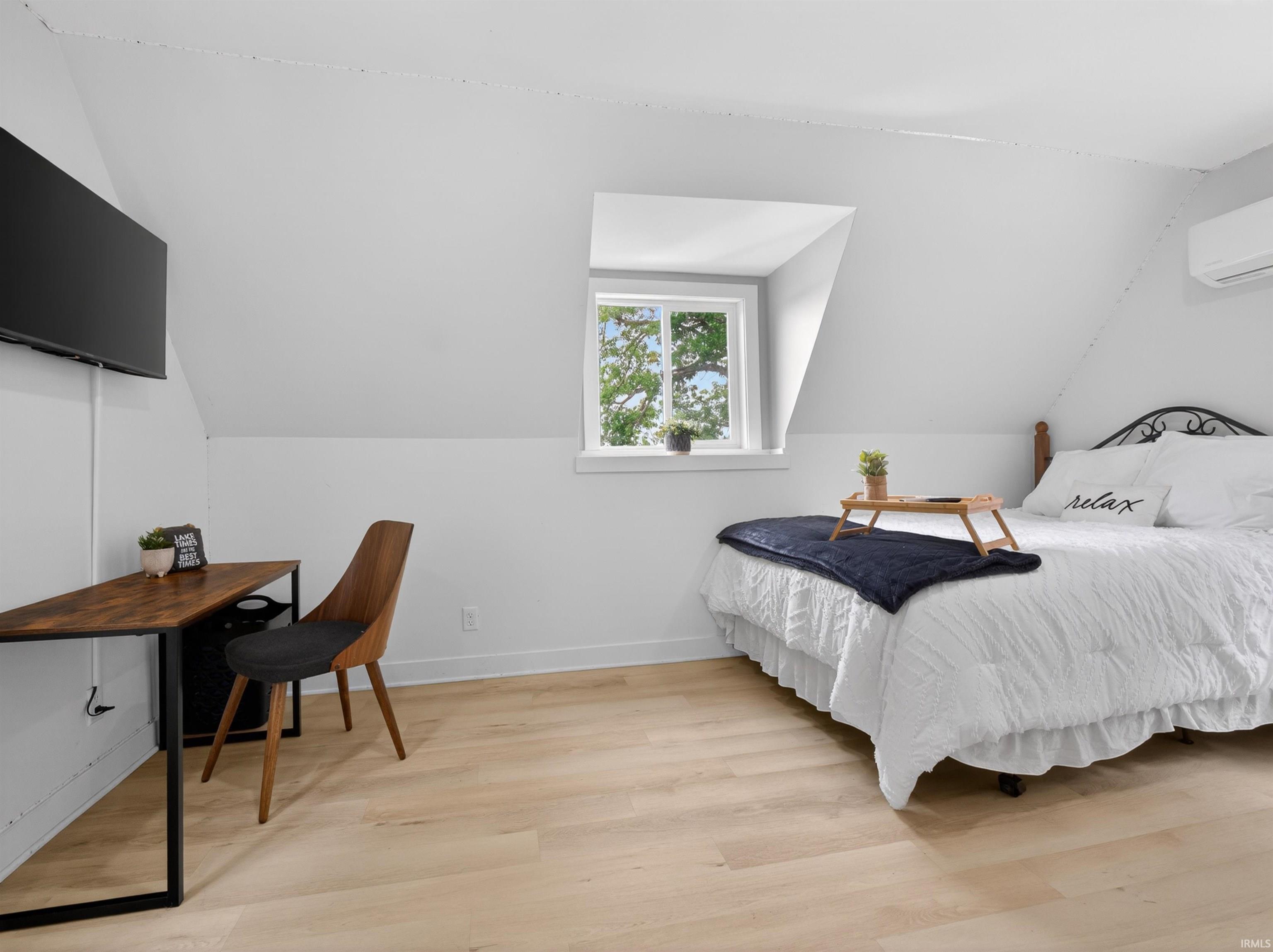 Attic space with light wood-finish flooring and sloped ceilings