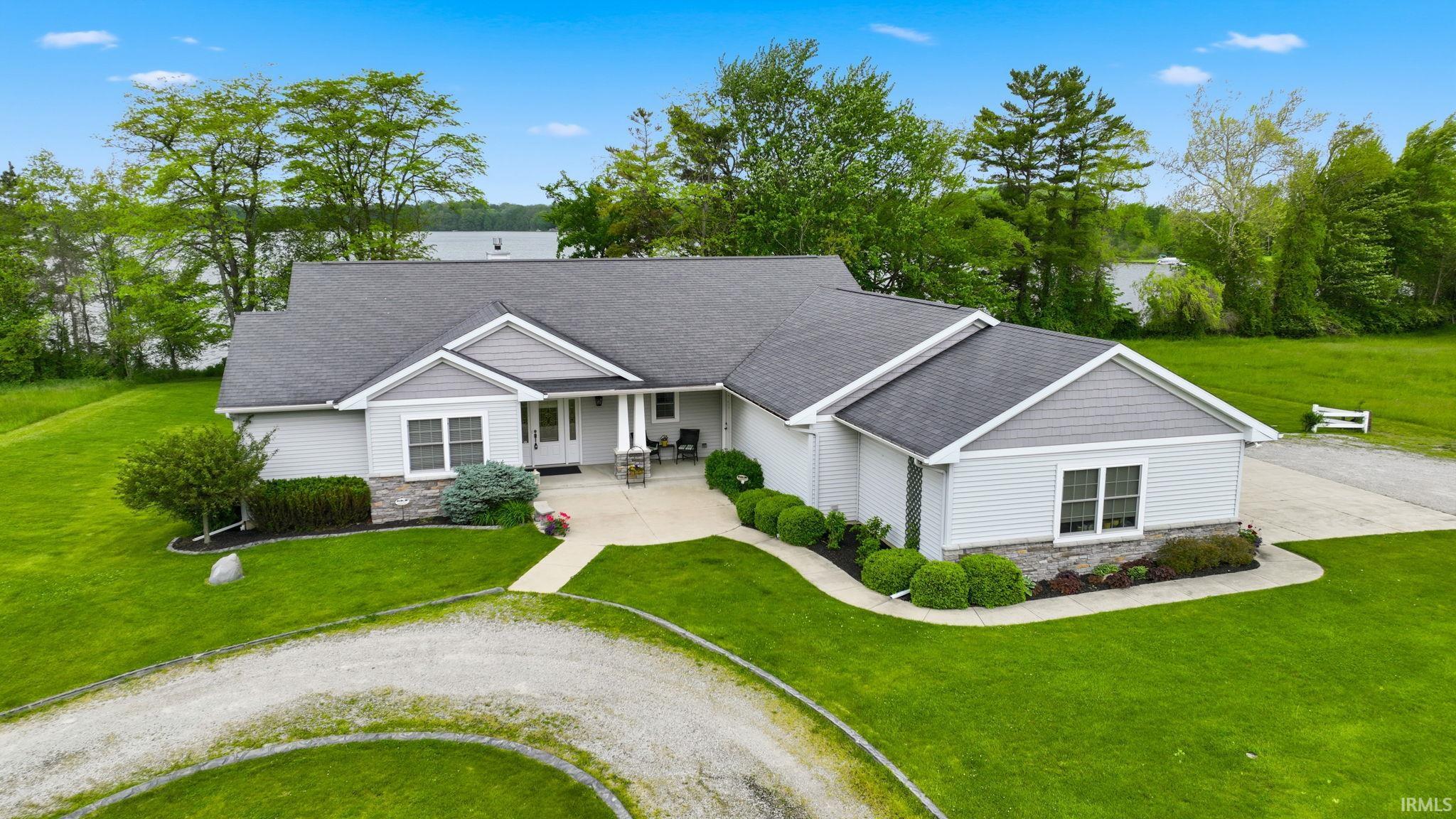 Ranch-style residence featuring light gray siding and stone accents