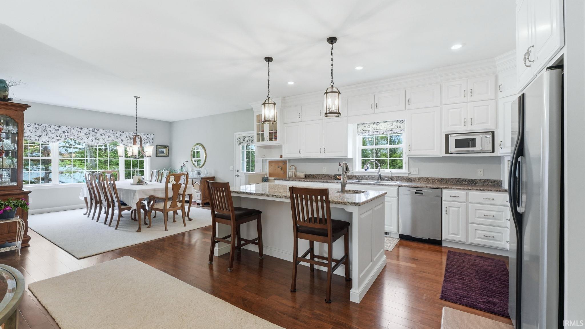 Open-concept kitchen and dining area featuring rich wood-finish flooring