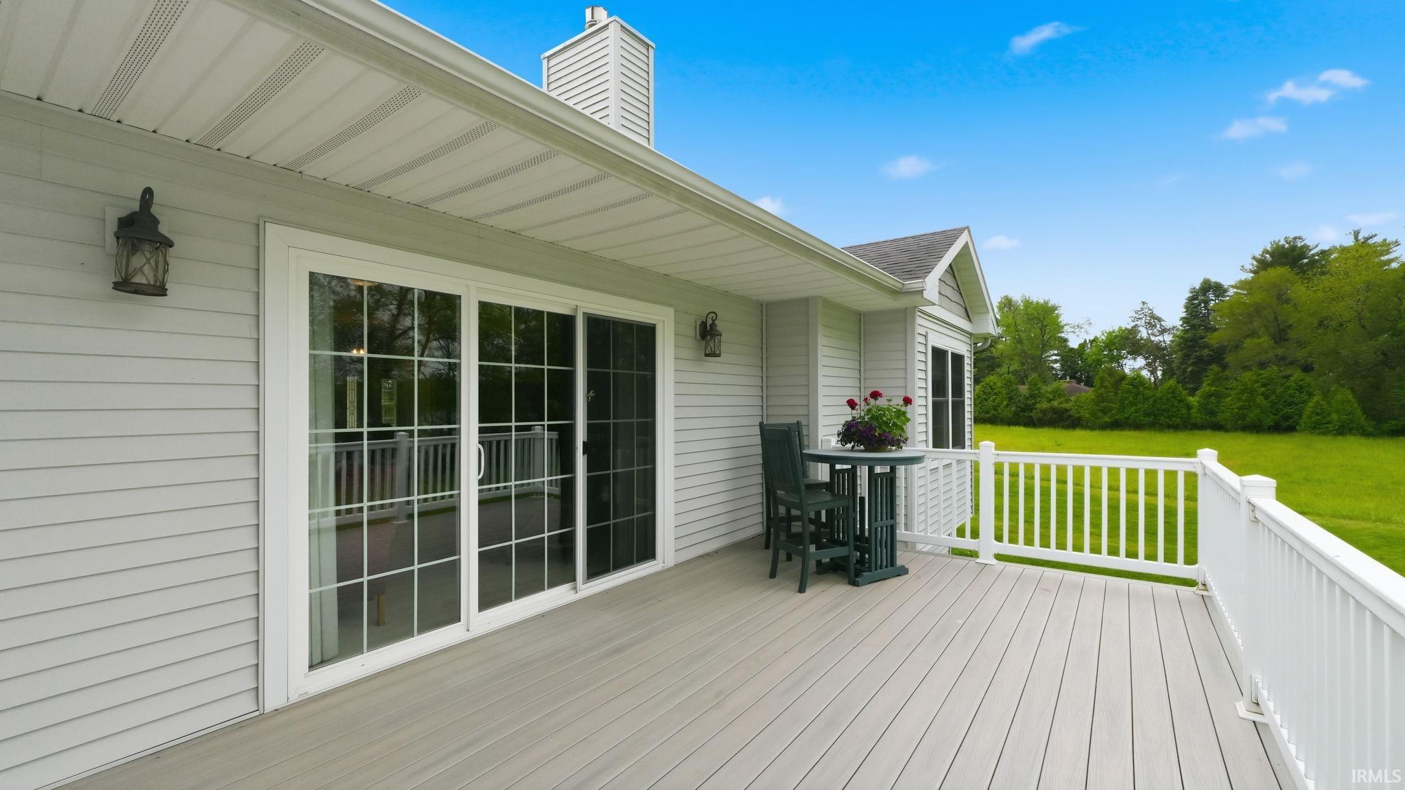 Expansive outdoor deck featuring wood-finish flooring and white railing