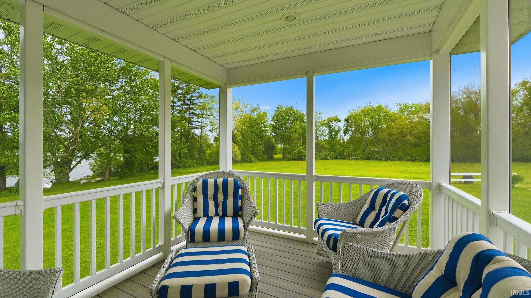Screened porch featuring a paneled ceiling, white baluster railings, and wood-finish flooring