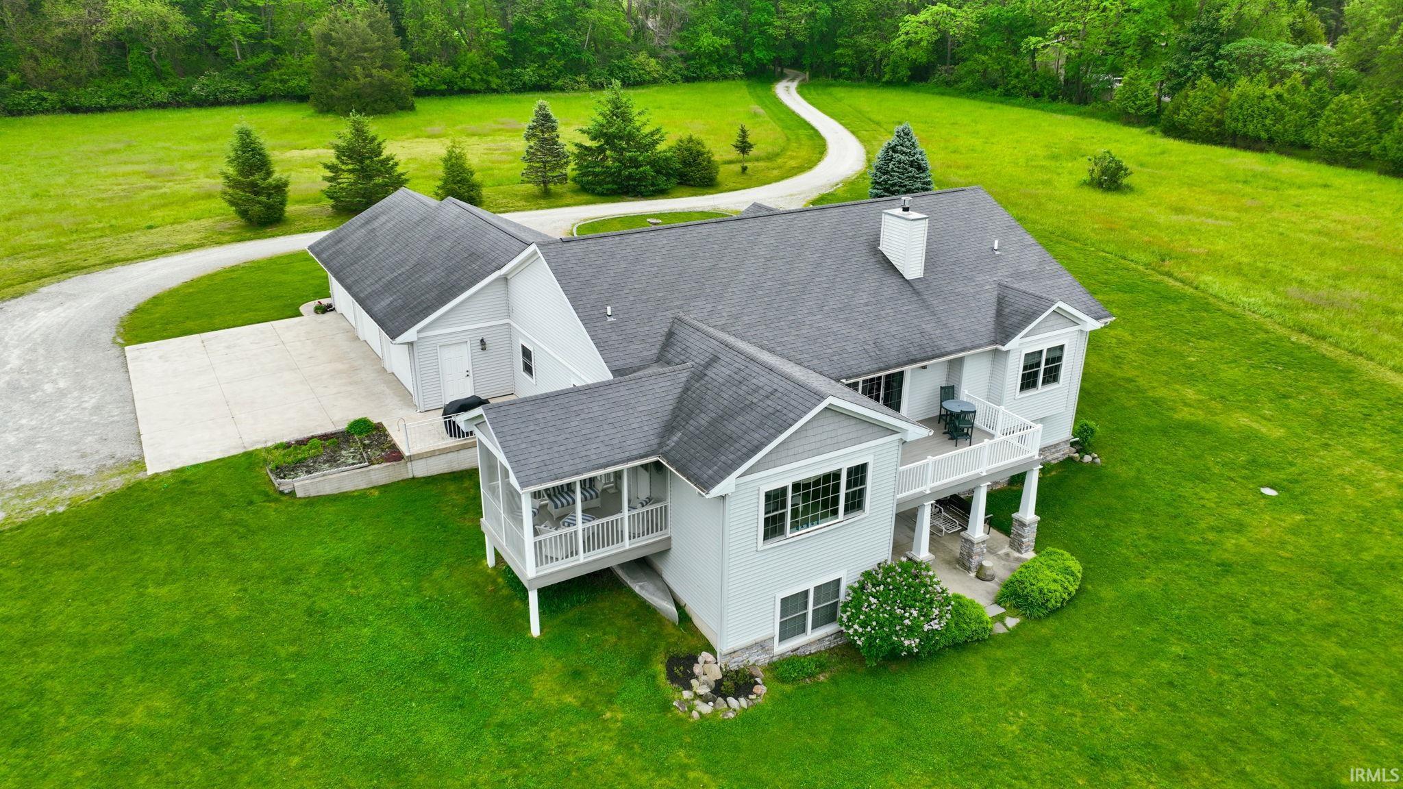 Contemporary residence featuring a light gray exterior, dark gray shingle roof, and multiple gables