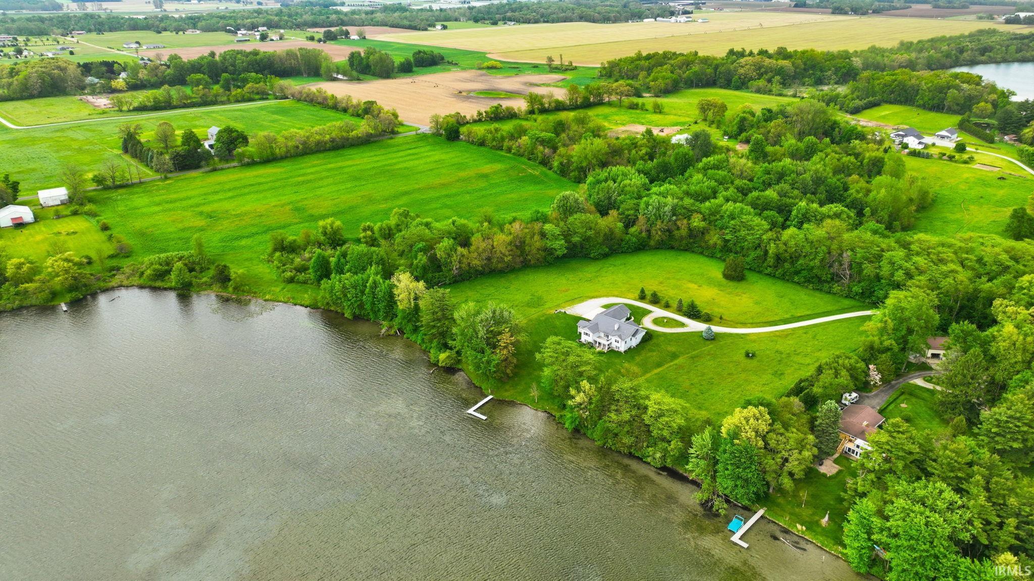 Expansive waterfront property featuring a large residence, two private docks, mature trees, and extensive green space