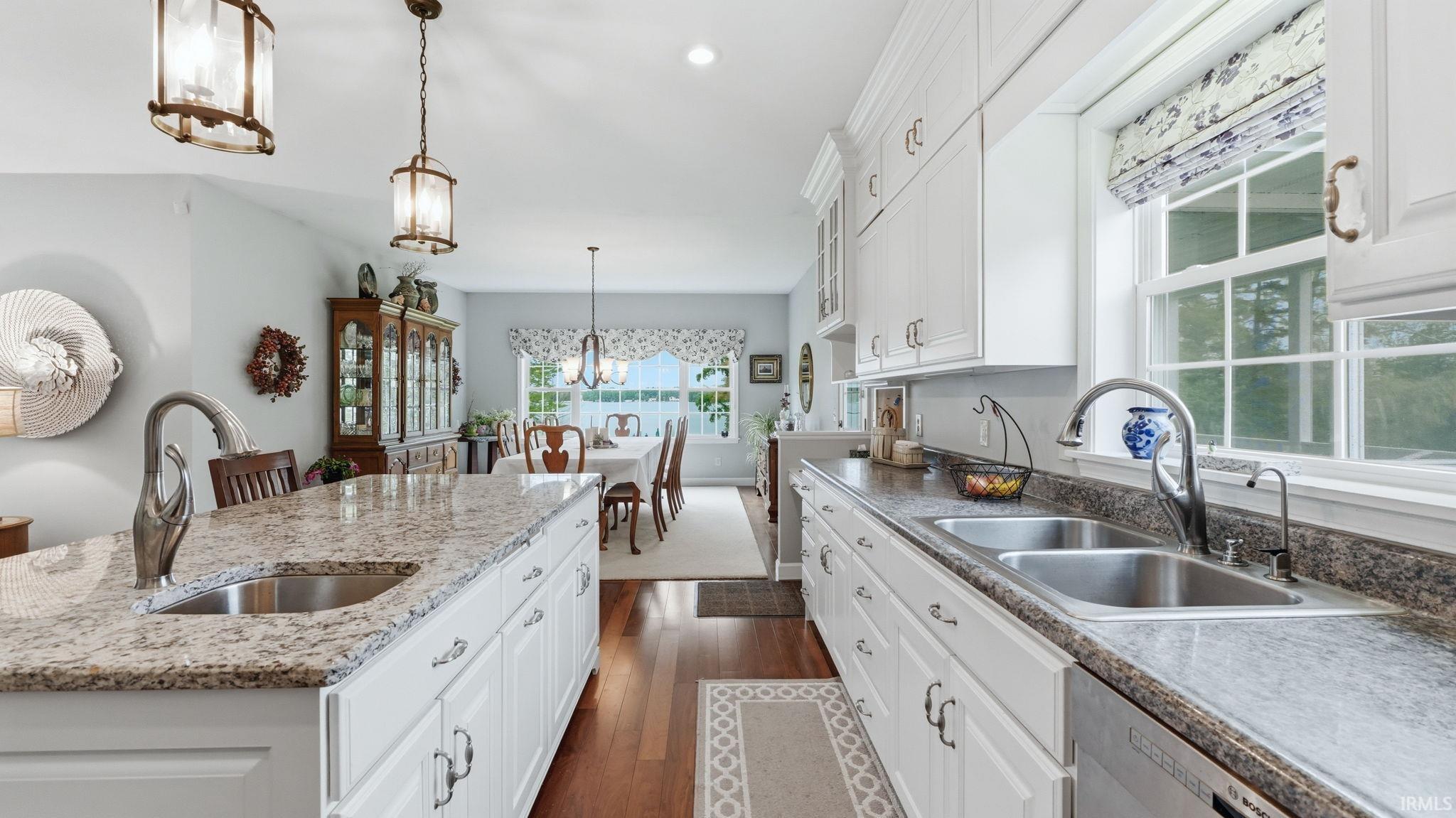 Kitchen featuring white cabinetry, granite countertops, hardwood-finish flooring, recessed lighting, and a double basin sink