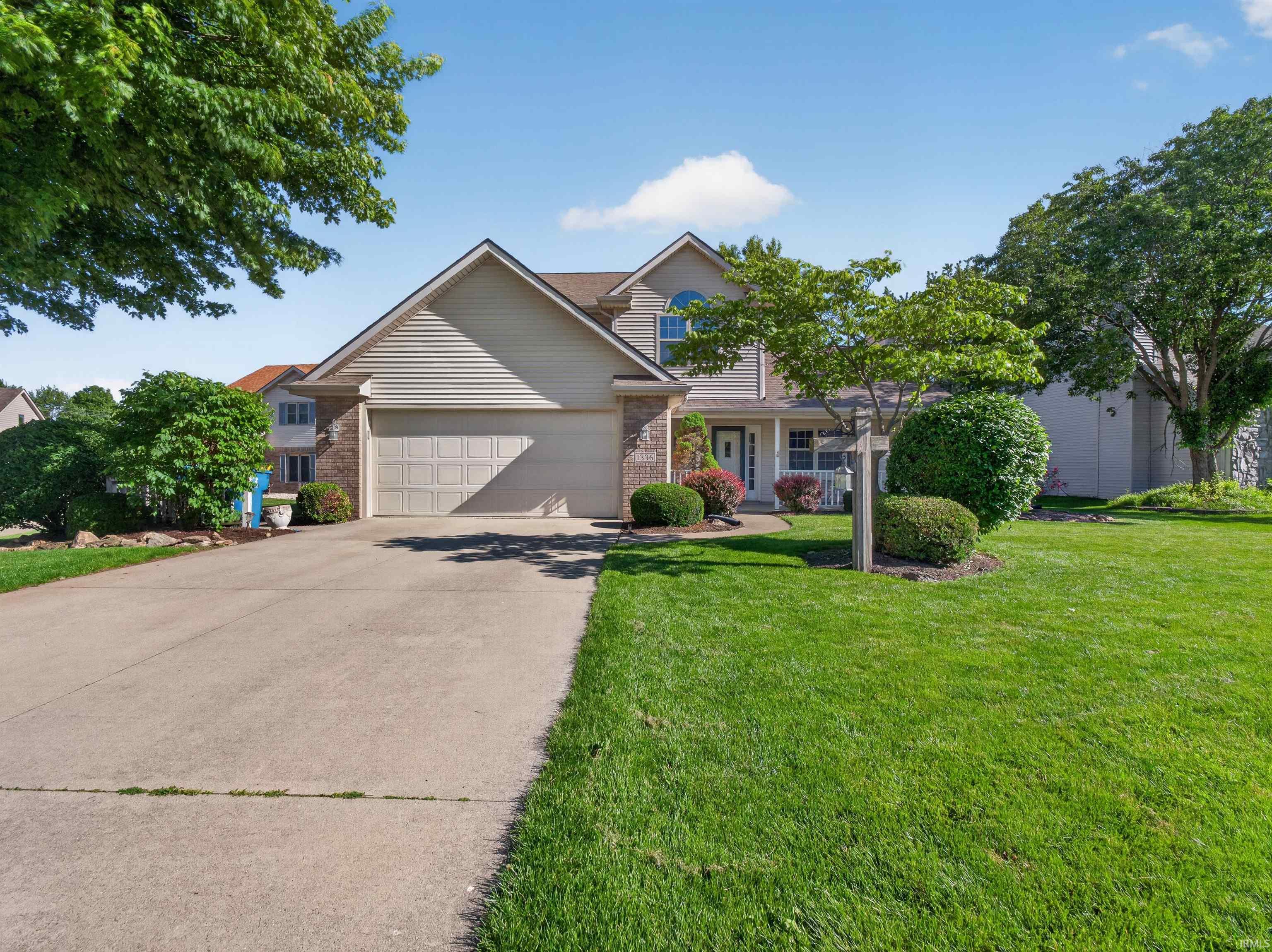 Two-story residence featuring brick and siding facade, an attached two-car garage, and a concrete driveway