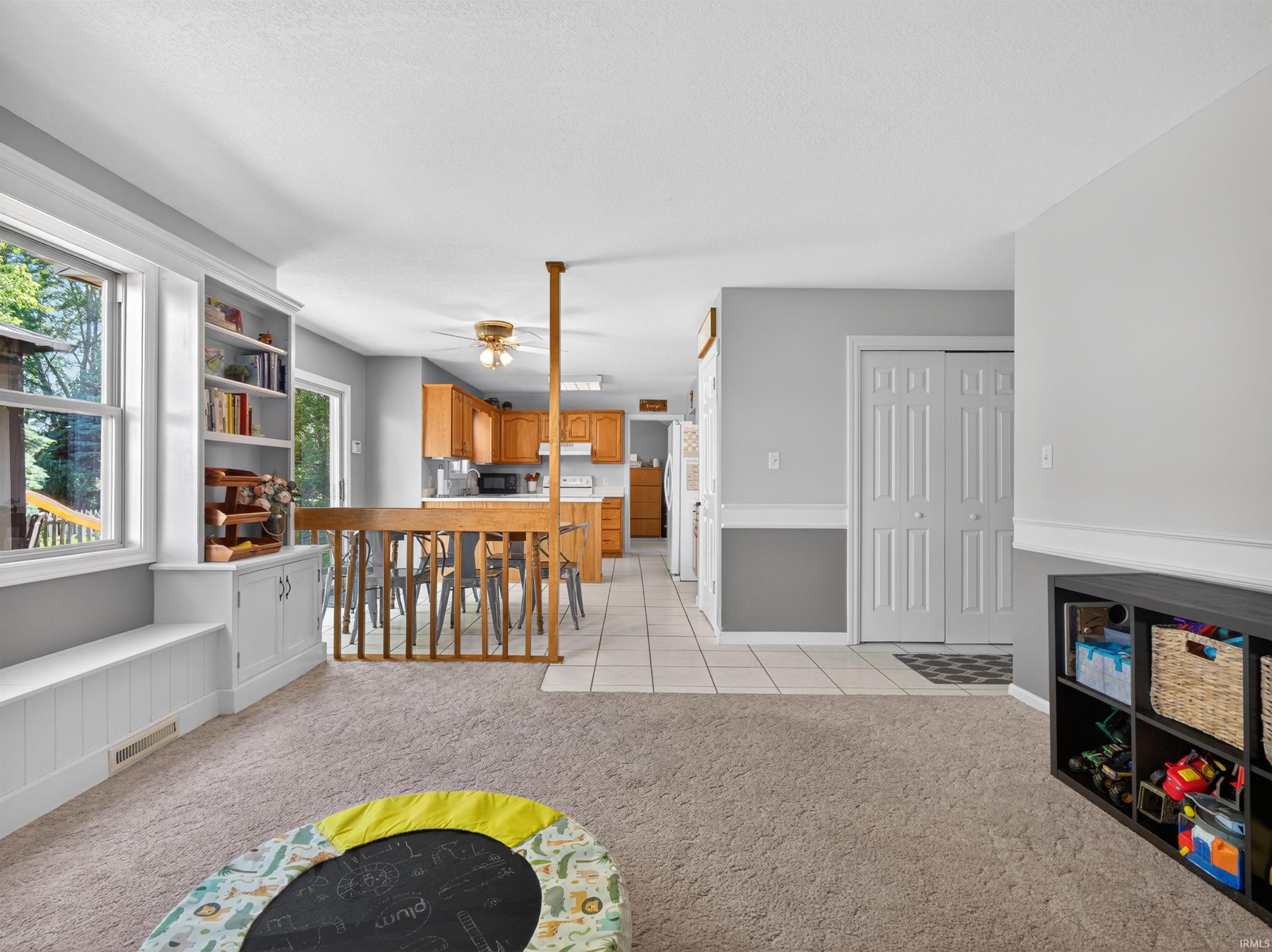 Carpeted main living area featuring built-in shelving, a window seat, and neutral wall tones
