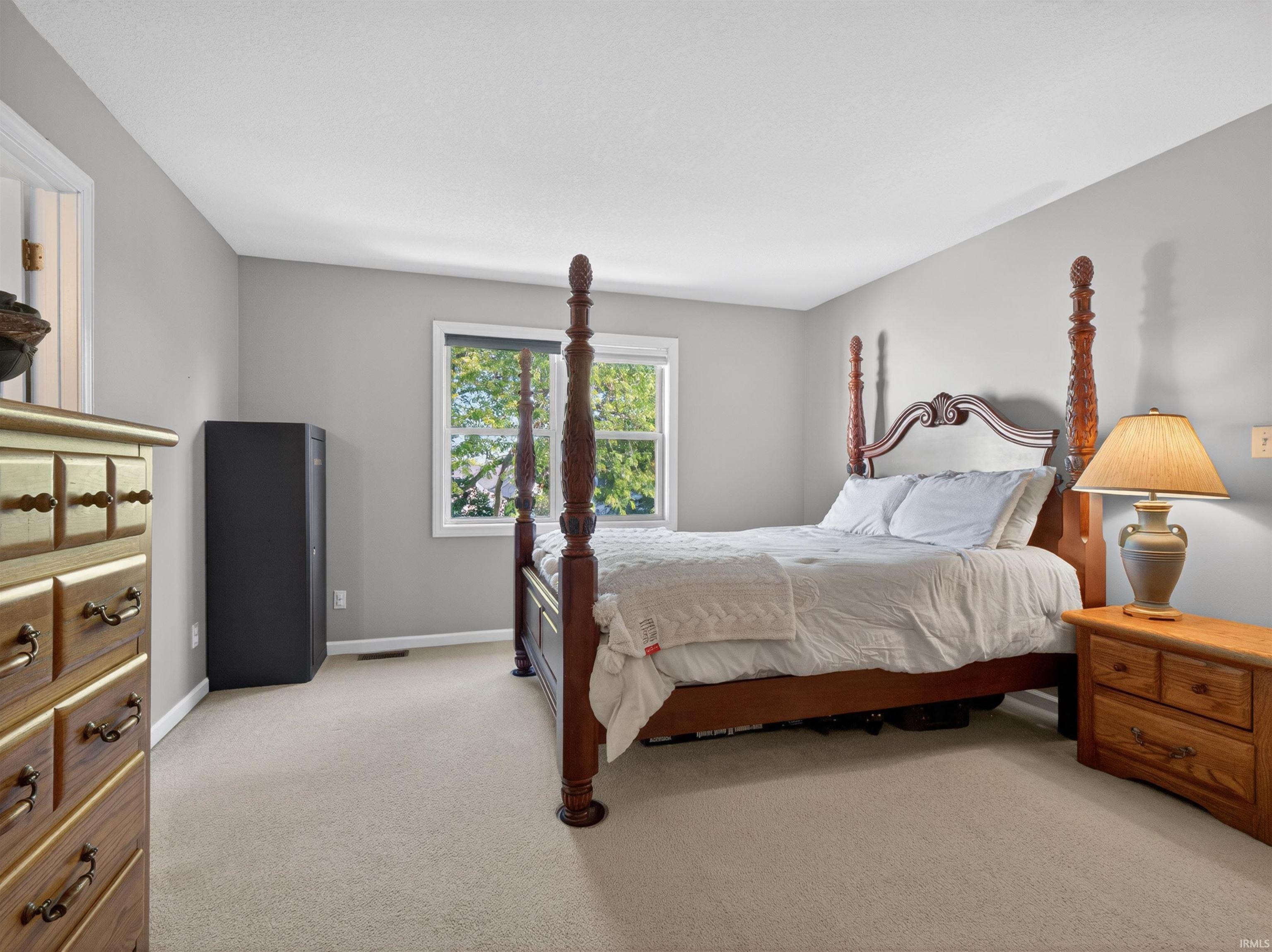 Bedroom featuring light gray walls and beige carpeting