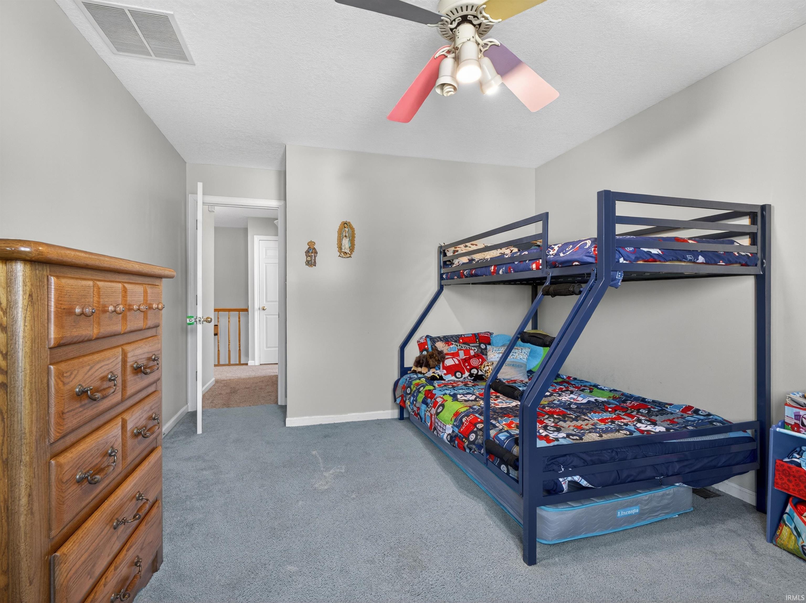 Carpeted room with light gray walls and a ceiling fan