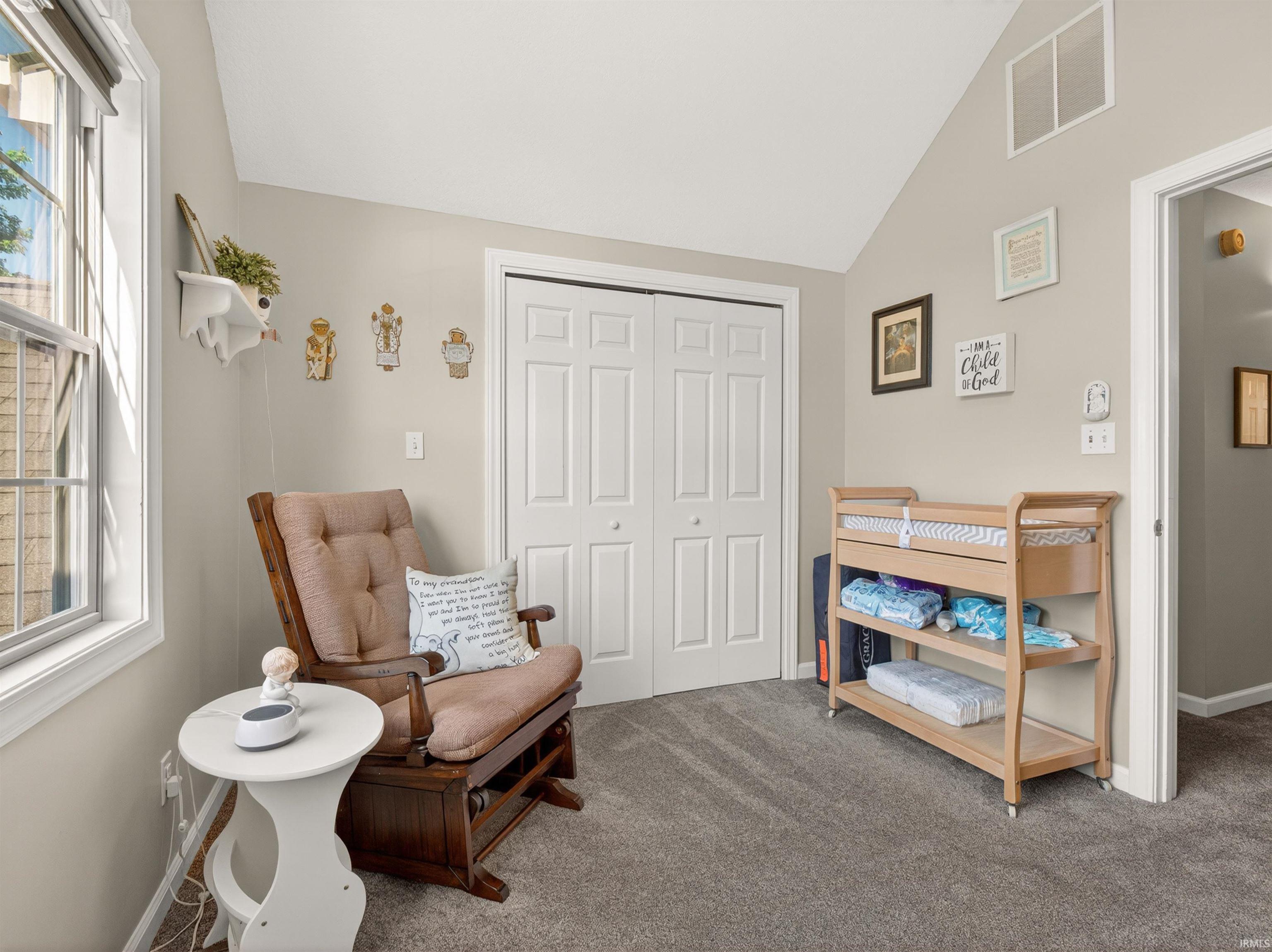 Vaulted ceiling room with neutral-toned walls
