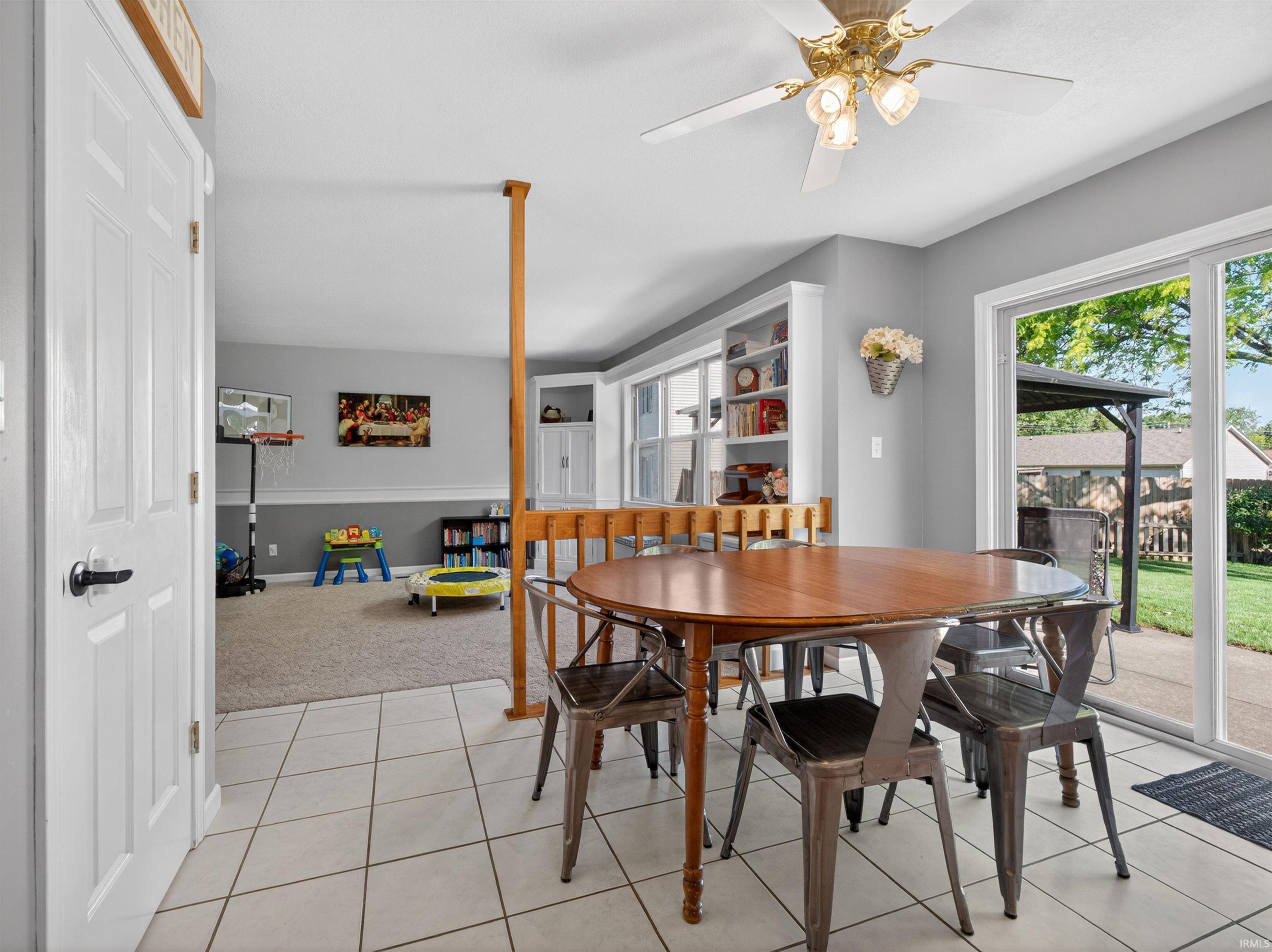Tiled flooring and a ceiling fan-light fixture define this dining area