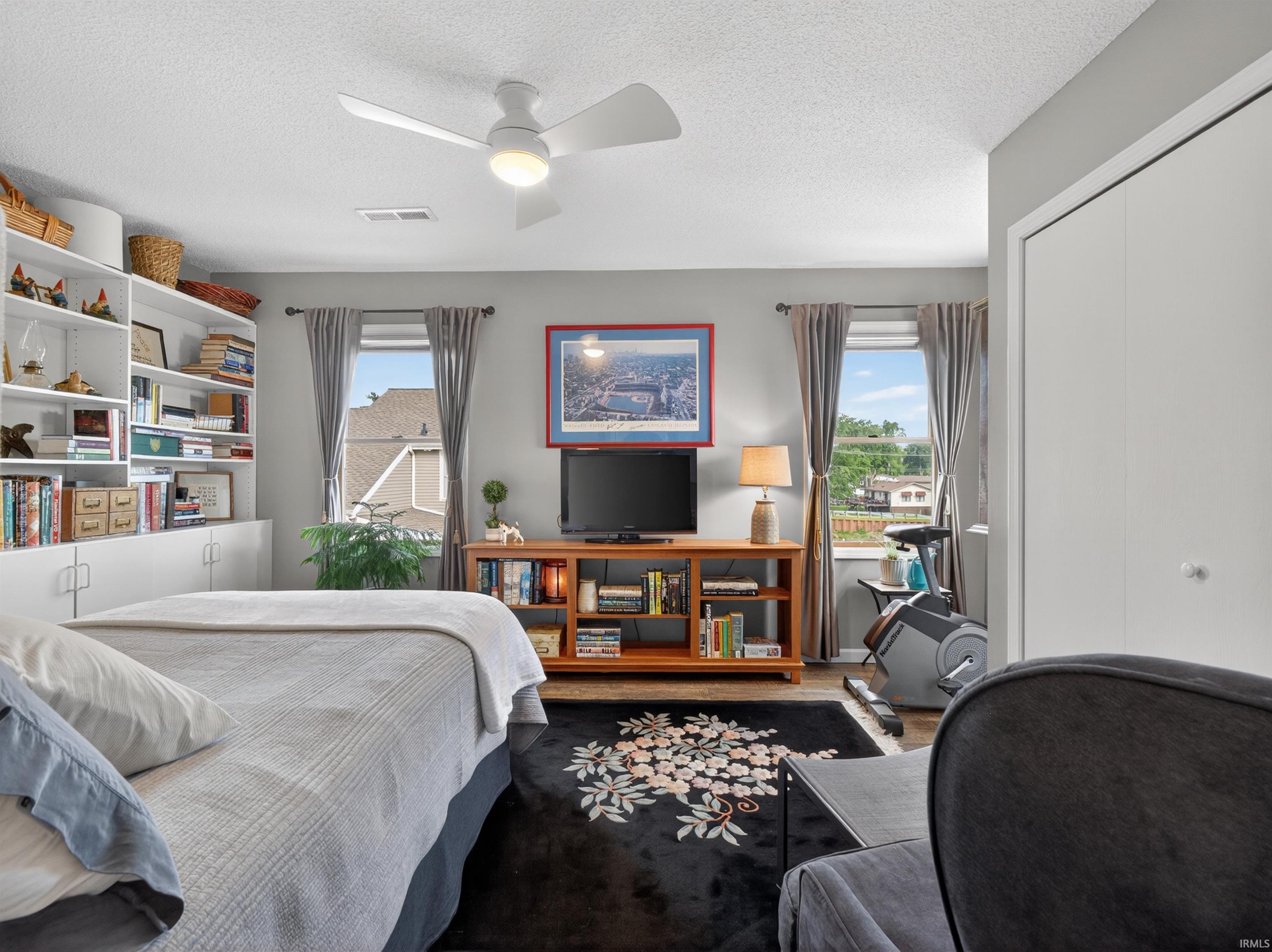 Interior room with a white ceiling fan, light gray wall paint, and a built-in shelving unit