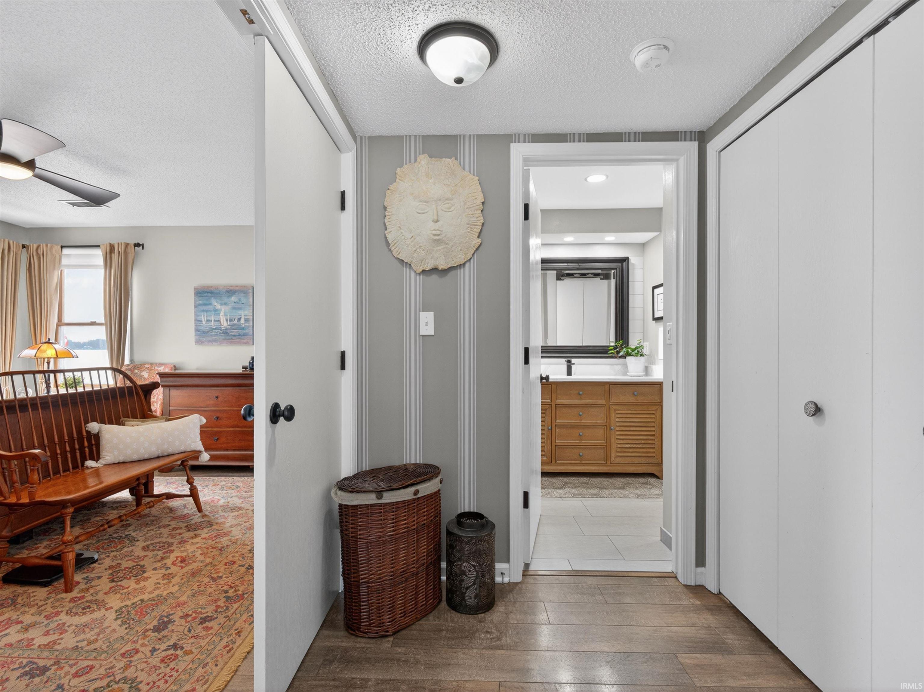 Hallway with wood-finish flooring and two white bi-fold closet doors