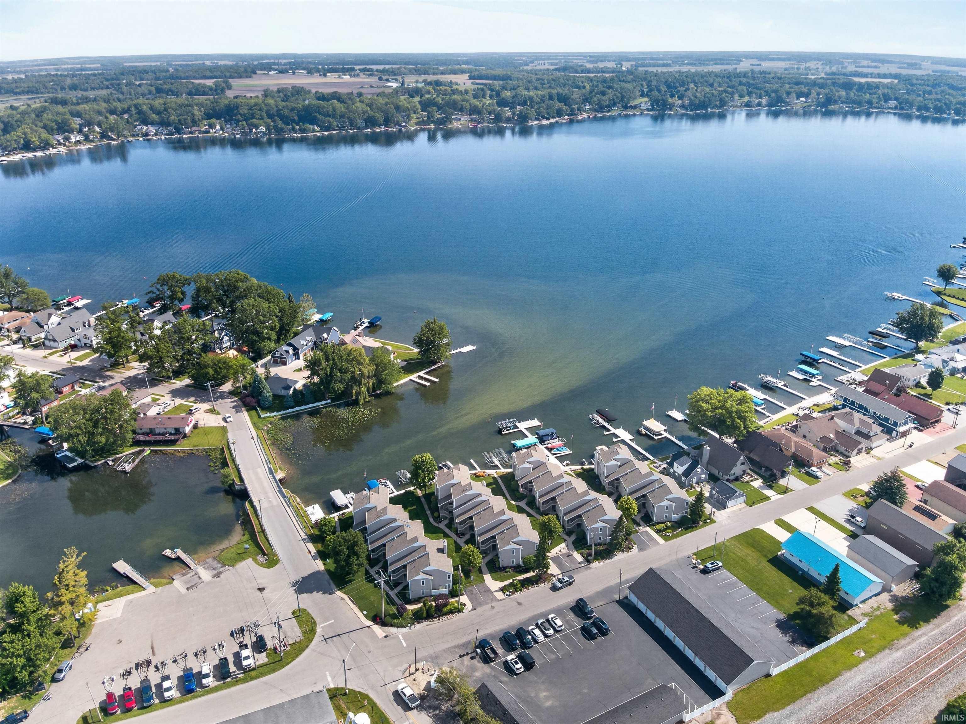 Aerial panorama showcasing expansive waterfront with multiple residential properties and docks