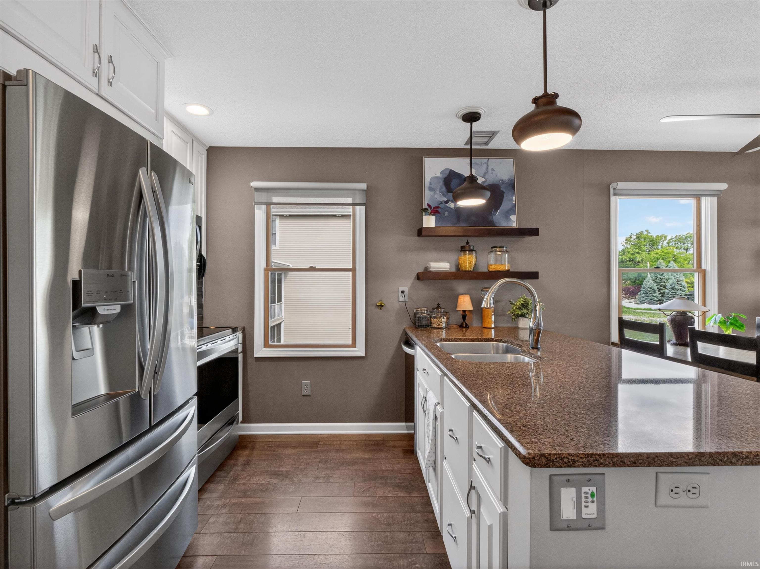 Kitchen island with a granite-finish countertop, stainless steel sink, and gooseneck faucet