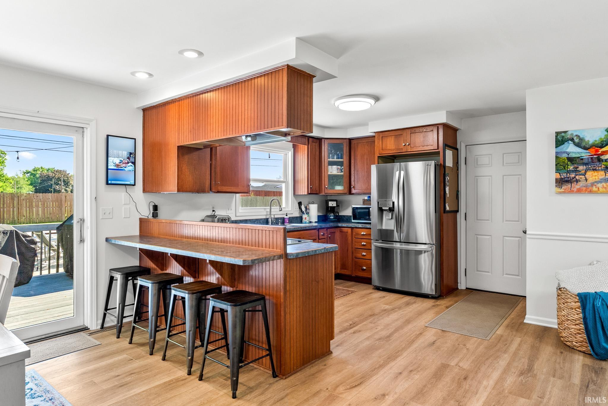 Kitchen featuring wood-finish cabinetry, stainless steel appliances, and a breakfast bar with built-in seating
