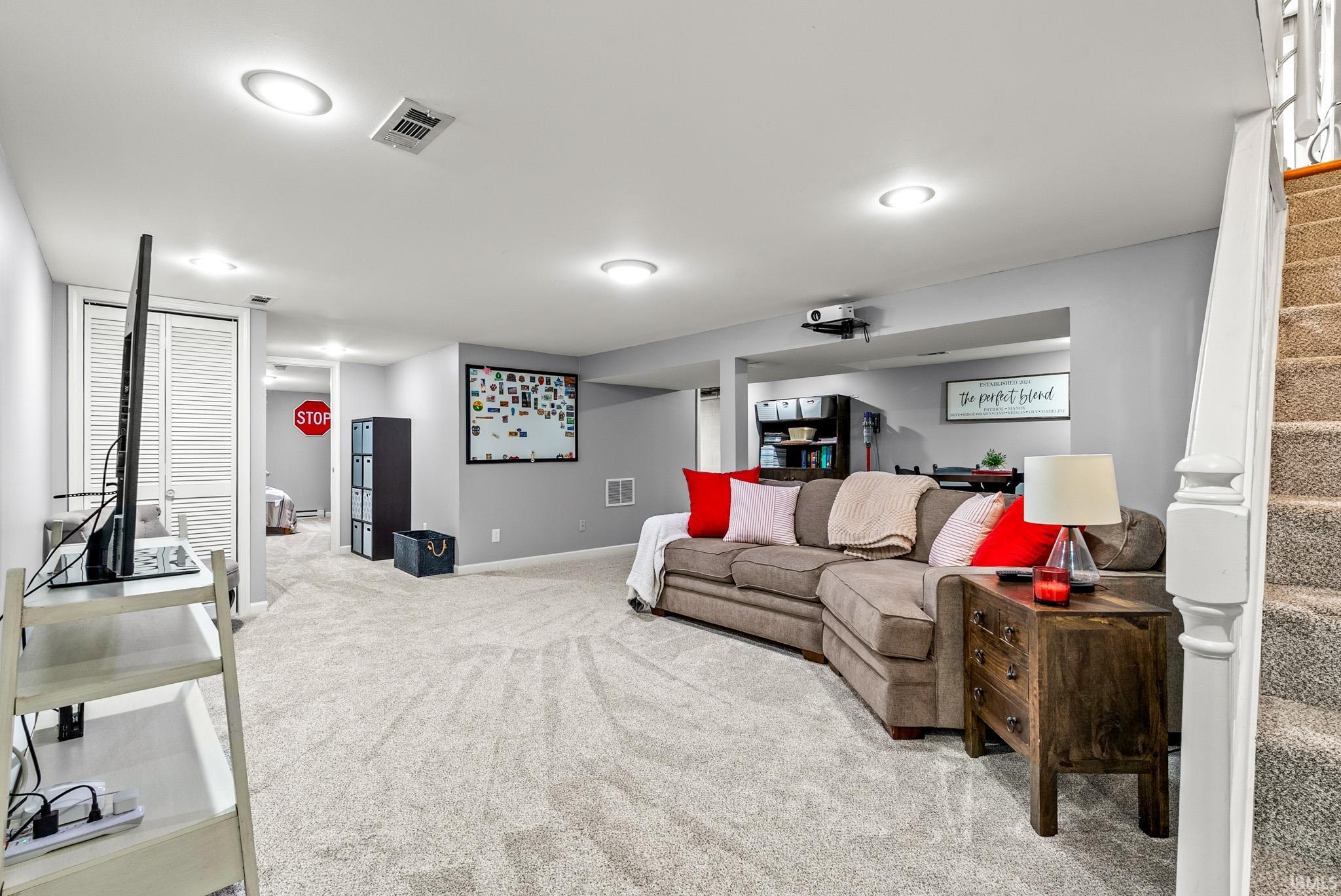 Finished basement featuring light gray walls, recessed lighting, and soft carpet flooring